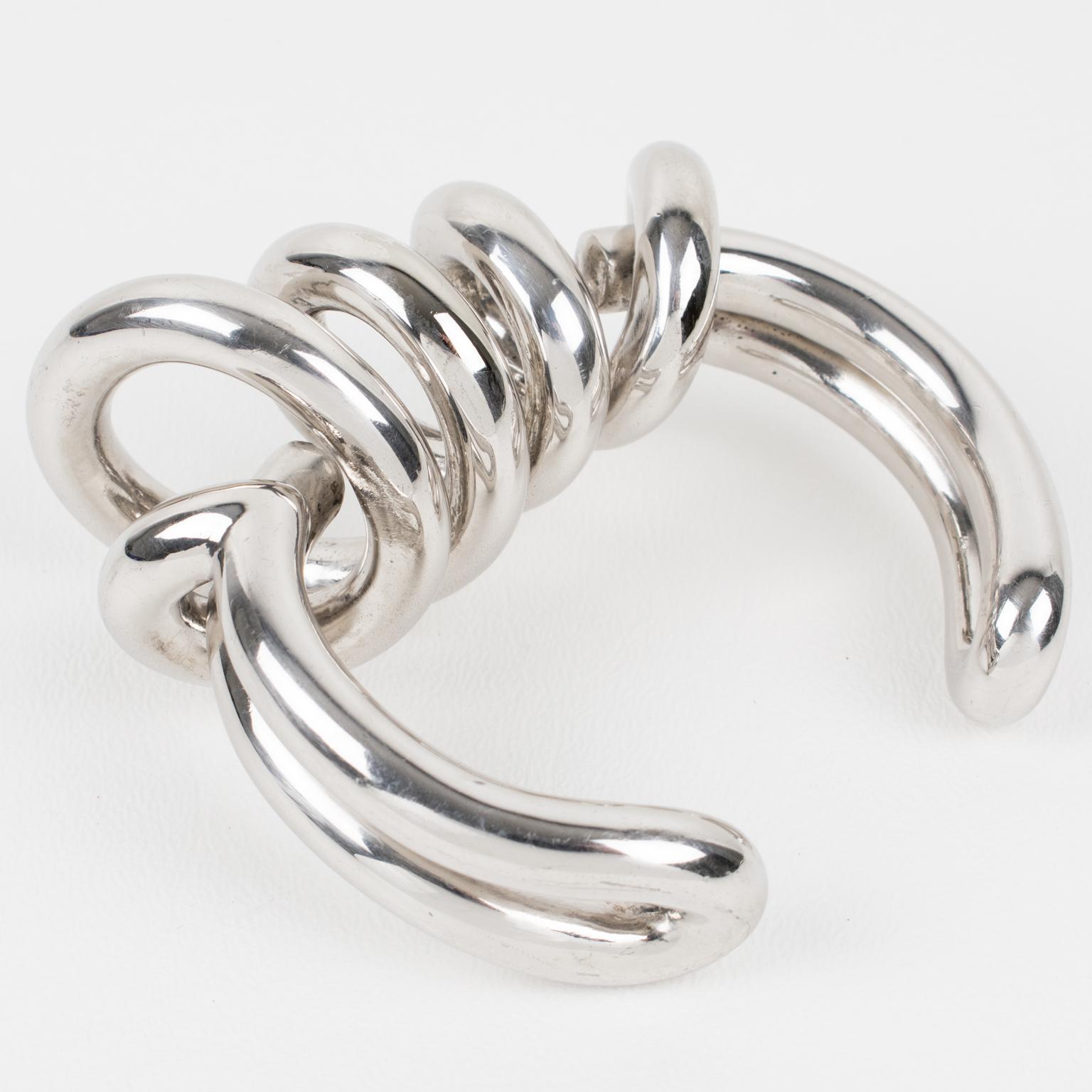Questo superbo bracciale bangle di alta moda è stato creato da Paco Rabanne per la sua sfilata prêt-à-porter dell'autunno 2014. La forma futuristica del bracciale vanta un pesante metallo cromato con un design geometrico. La firma incisa 