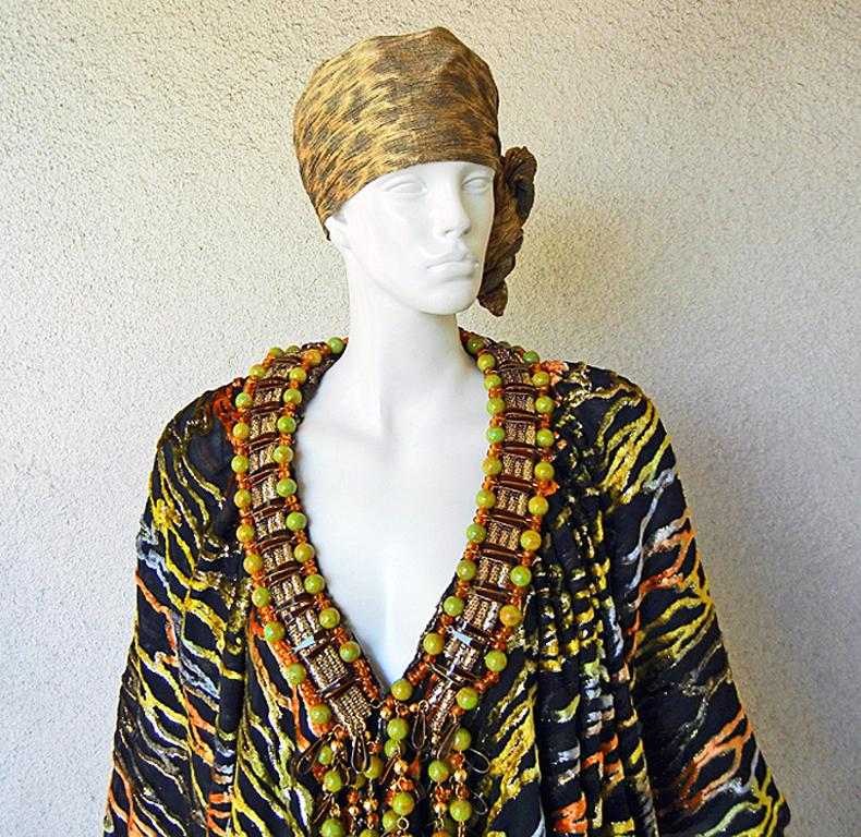 A one-of-a-kind Couture Paco Rabanne circa 1970's.

Fashioned of black burnout silk velvet with colors of orange, yellow, gold, in a zebra pattern. The attached oversized long Sautoir necklace adds to the drama and richness of the look. 

The