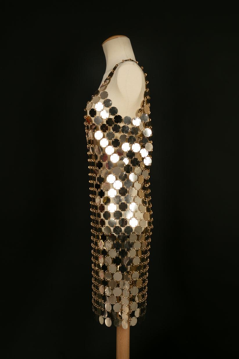 Paco Rabanne - Iconic dress made from gold celluloid pellets. No size or composition label, it fits a 36FR. To note, presence of marks on the pellets.

Additional information:
Dimensions: Chest: 45 cm, Length: 90 cm
Condition: Very good