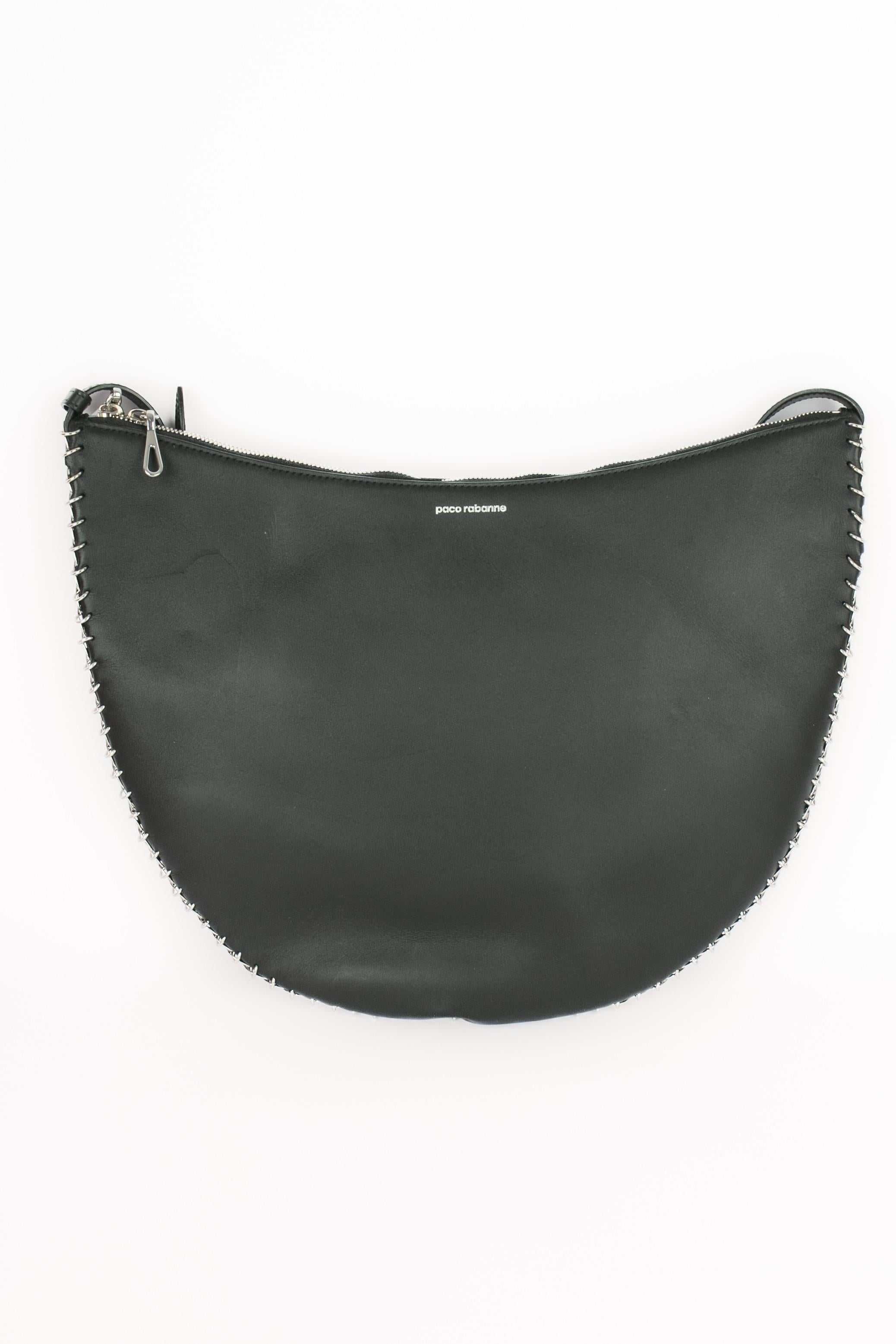 PACO RABANNE - (Made in Italy) Halbmondförmige Ledertasche, deren Kanten mit silbernen Pastillen verziert sind.

Bedingung:
Guter Zustand

Abmessungen:
Höhe: 30 cm - Breite: 40 cm - Tiefe: 3 cm - Stiel: 80 cm

SKU:S287