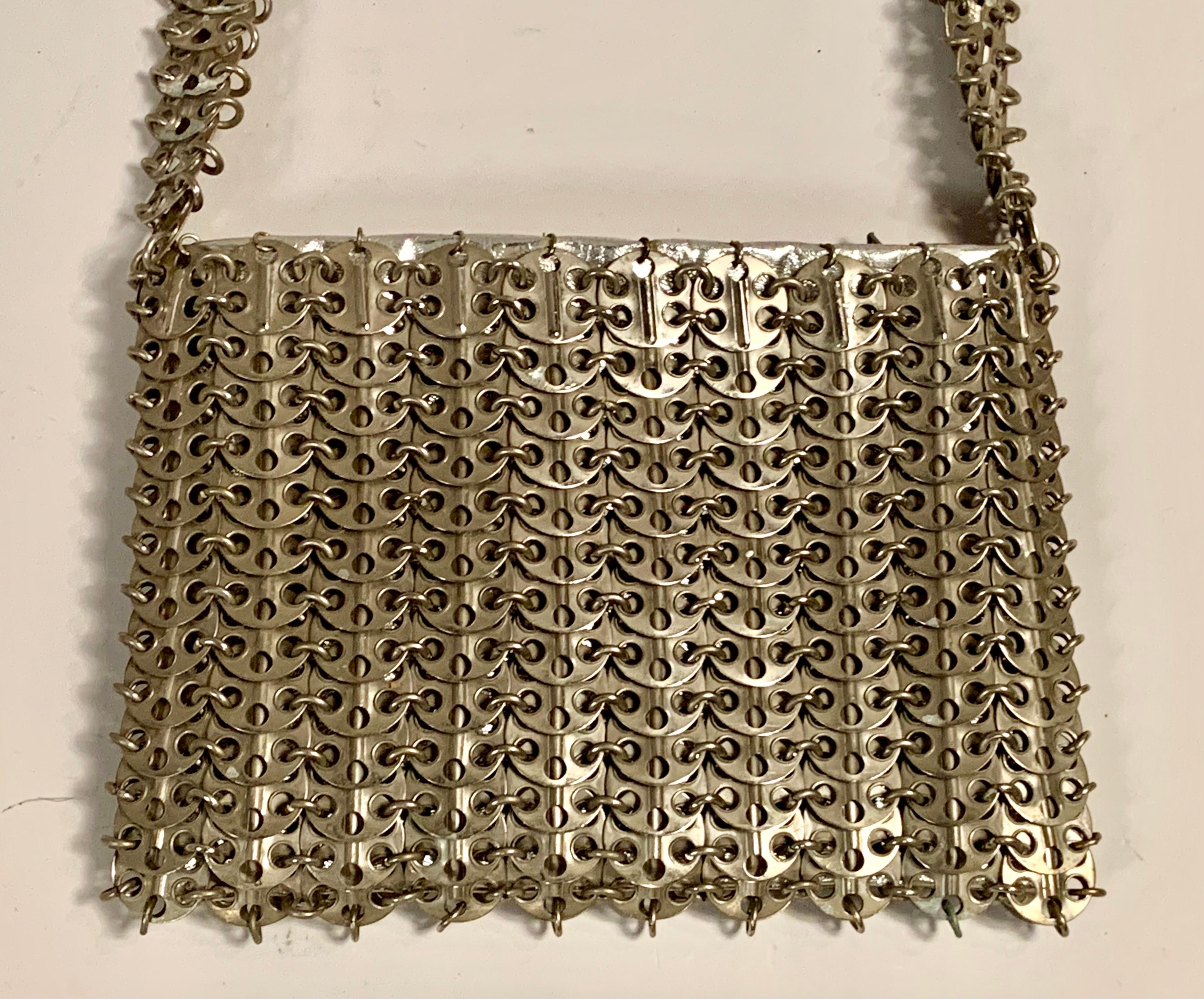 French designer Paco Rabanne is best known for his revolutionary 1968 dresses made from metal discs and rings. This rare handbag soon followed, made from the same materials. The bag has a shoulder strap, an interior silver leather pouch which has a
