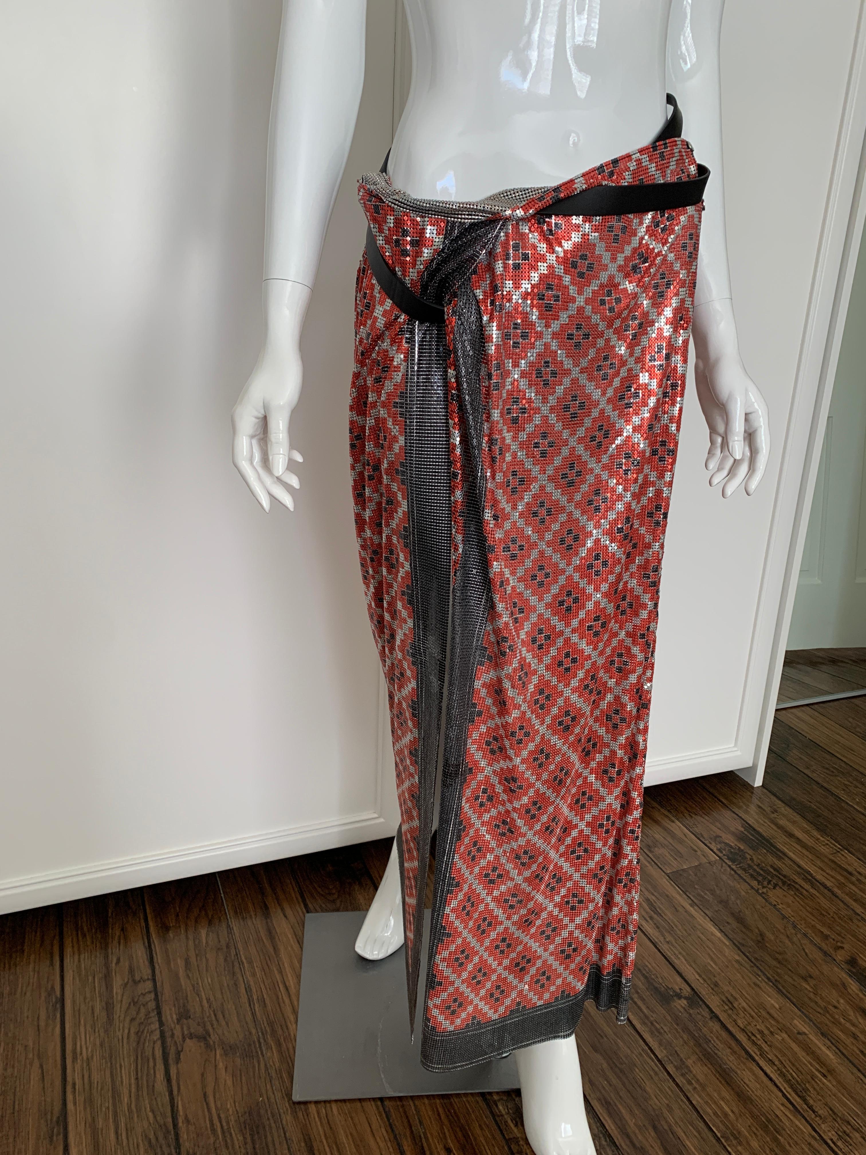 This skirt is a piece of art. Wrap in style, long in length, with slit opening. The belt is brown leather. with a silver ring and can be wrapped and adjusted for one's interpretation of styling the skirt. 

The skirt is red, black, and silver on the