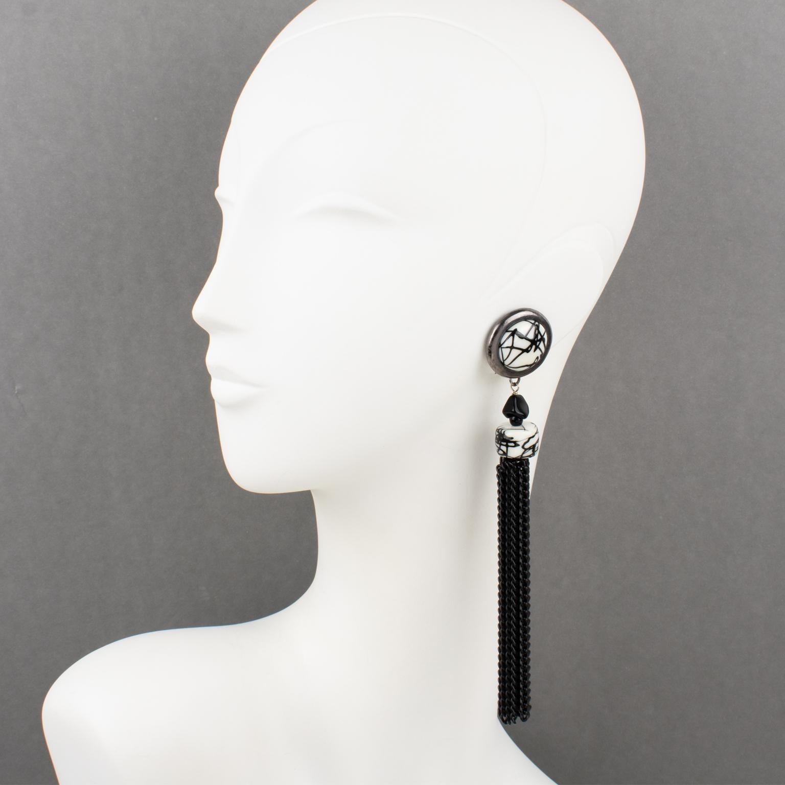 These lovely Paco Rabanne Paris futuristic clip-on earrings feature an oversized shoulder-duster dangling drop shape with gunmetal framing, topped with resin cabochons and beads in black and white colors and complemented with an extra long black