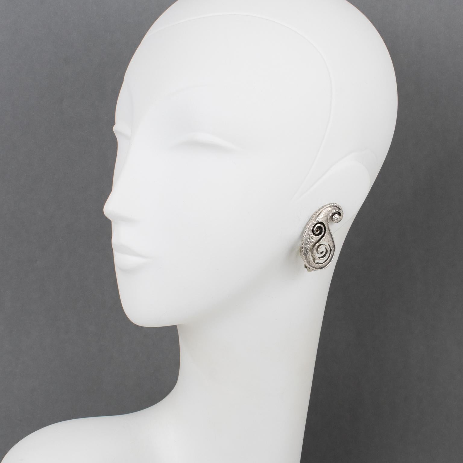 Paco Rabanne Paris entwarf diese futuristischen Ohrringe aus Metall in den 1990er Jahren. Das Design besteht aus einer leicht gehämmerten, durchsichtigen Kommaform aus Silberblech mit Schnitzereien. Die Clips sind an der Unterseite mit dem