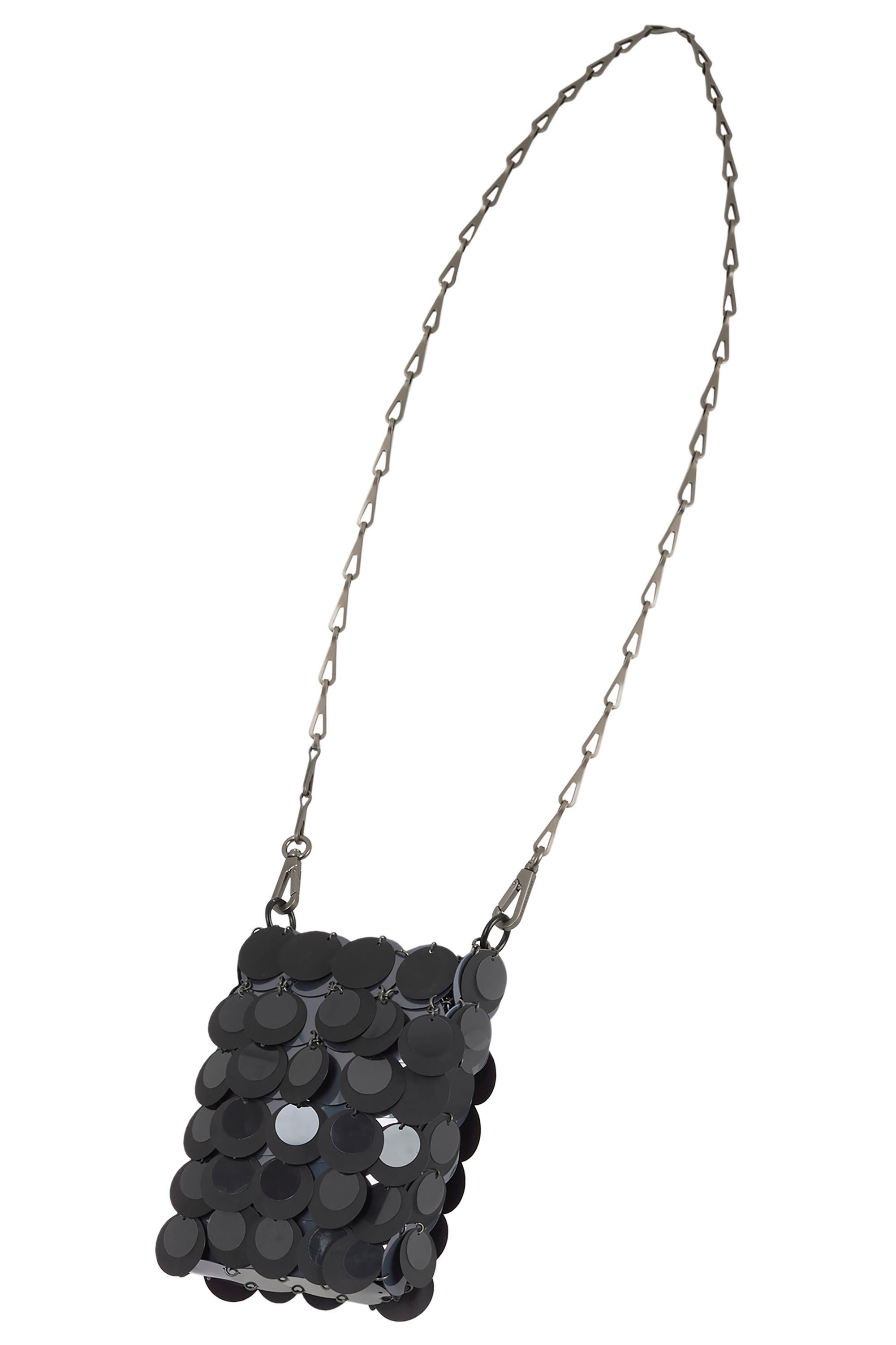 Una rara miniatura di Paco Rabanne, dal design rivoluzionario del 1969, questa nano borsa è realizzata con dischi e anelli neri sospesi da una tracolla a catena allungata e articolata. 

In eccellenti condizioni vintage. 

Marchio: Paco