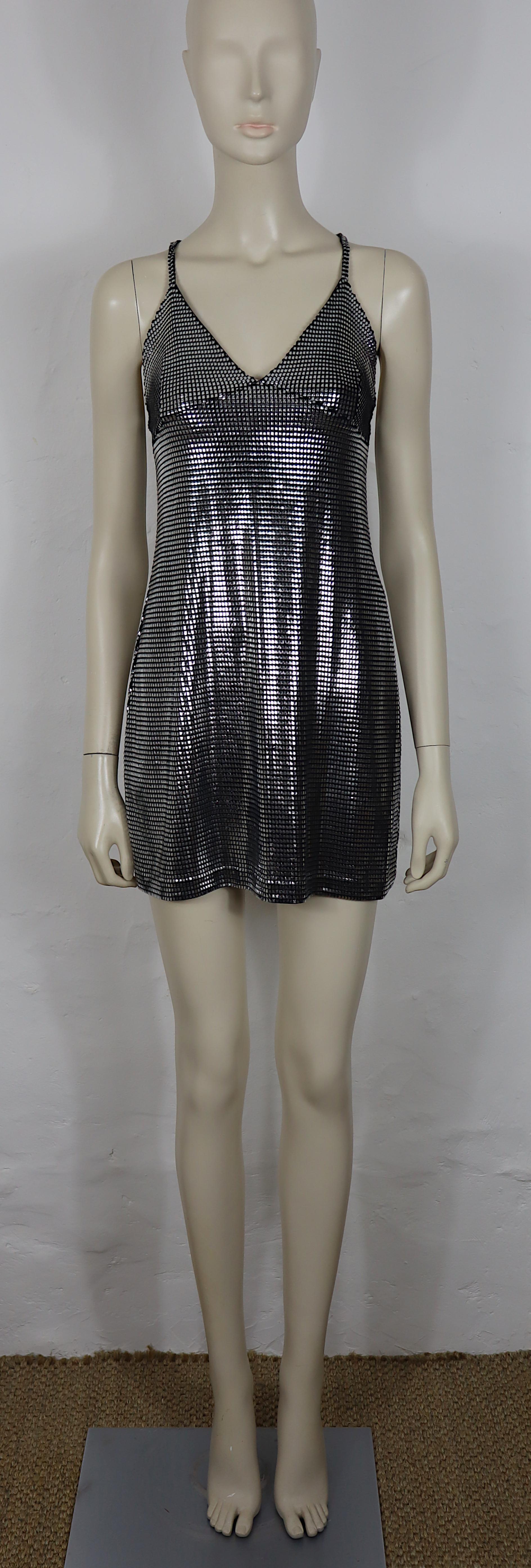 PACO RABANNE Kleid aus silbernem Foliengitter.

Die Oberseite ist mit Silberfolie bedruckt und erzeugt einen metallischen Kettenhemd-Effekt auf einem schwarzen Elasthan-Grundgewebe.

Überkreuzte Schulterriemen auf dem Rücken.

Auf dem Label steht