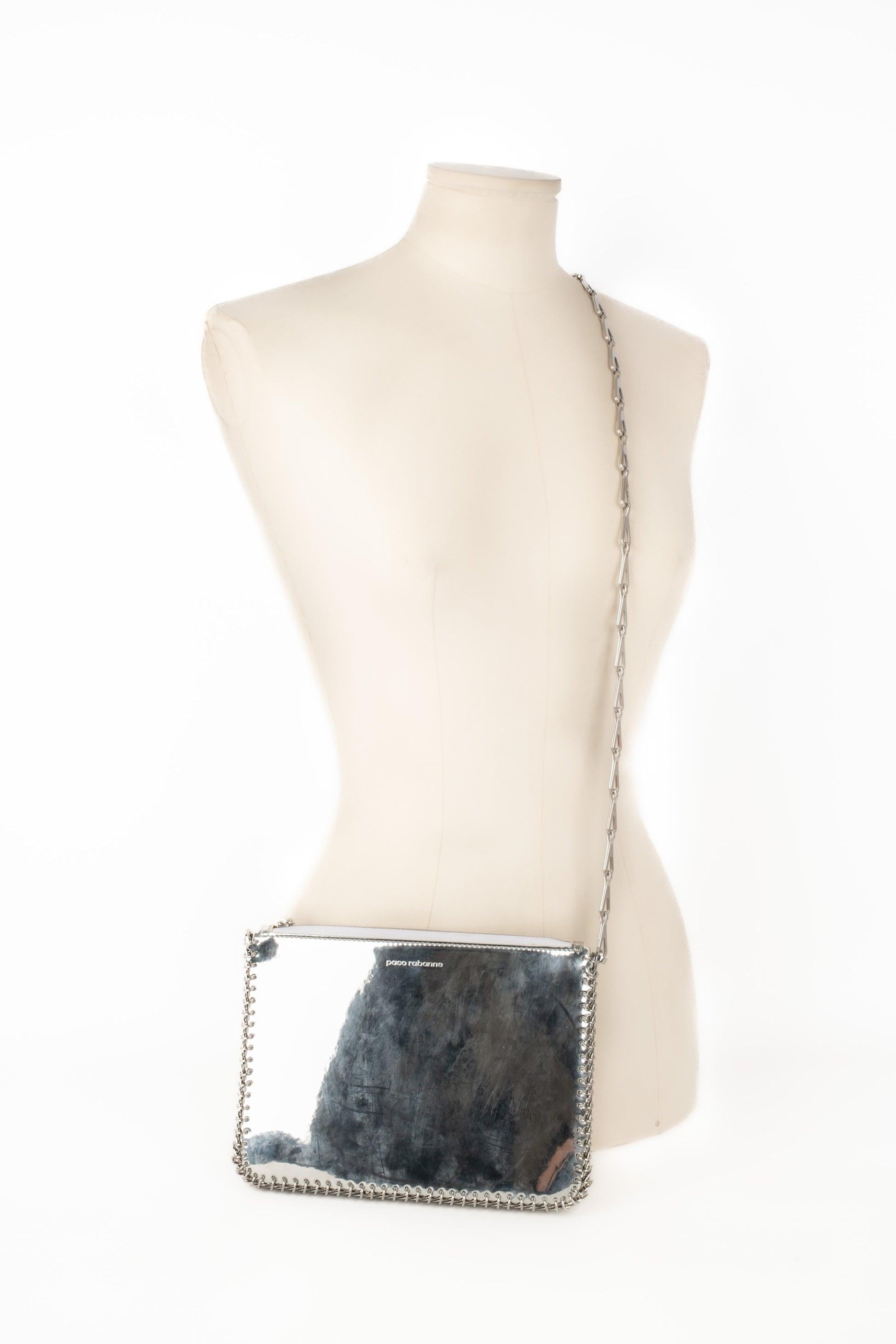 Paco Rabanne - (Made in Italy) Silvery leather bag with mirror effect, edged with silvery metallic pastilles. White leather inside.

Additional information:
Condition: Good condition
Dimensions: Length: 22 cm - Height: 15 cm - Depth: 2 cm - Handle: