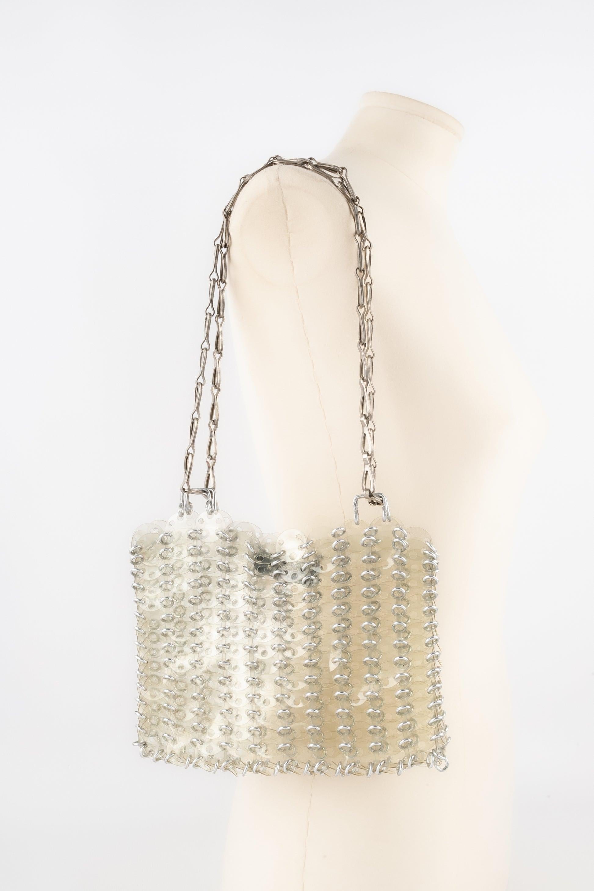 Paco Rabanne - (Made in France) Transparent celluloid pastilles bag assembled with silvery metal rings. 1969 design.

Additional information:
Condition: Very good condition
Dimensions: Height: 14 cm - Width: 23 cm - Handles: 56 cm // 100 cm
Period: