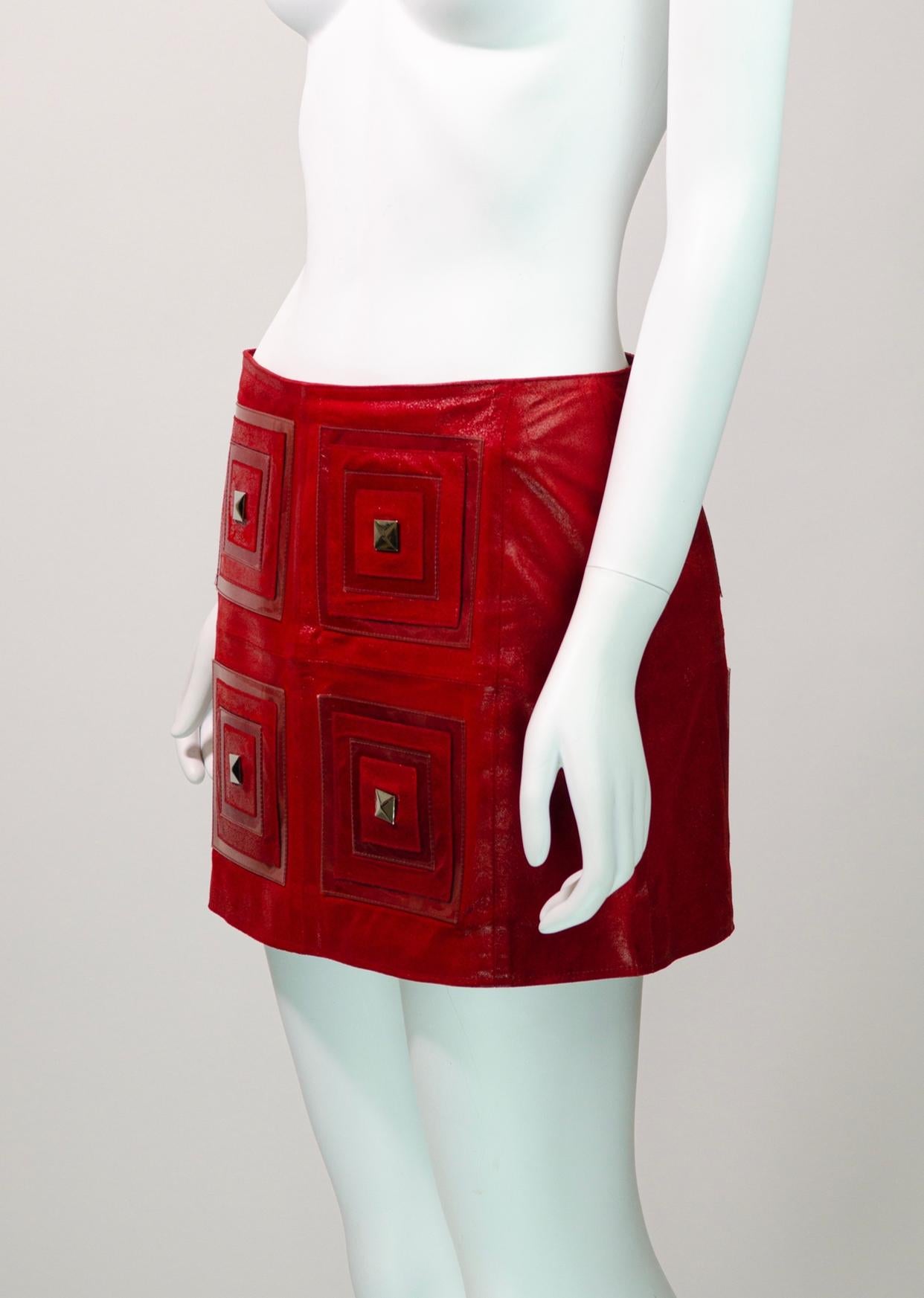 Magnifique et rare jupe vintage Paco Rabanne de sa collection printemps-été 2002.

Fabriquée à partir d'un cuir rouge souple, cette mini-jupe unique présente quatre carrés à l'avant et à l'arrière qui sont embellis par des clous argentés et des