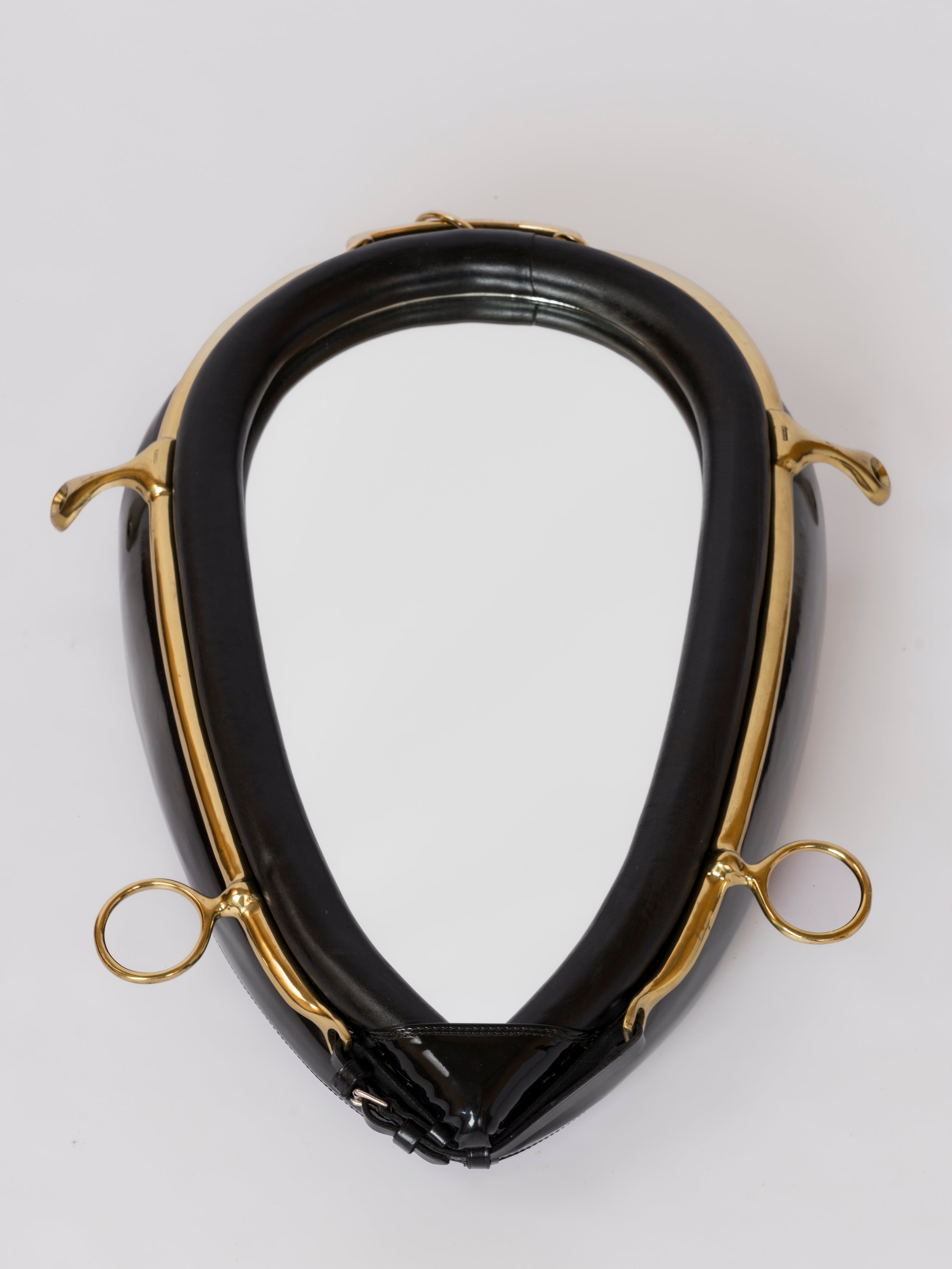 Wandspiegel im Stil von Hermès aus schwarzem Lederimitat mit Messingbändern und -verzierungen zum Thema Reitsport.
Gürtel und Schnalle am unteren Ende des Spiegels vorhanden.
In gutem Vintage-Zustand. Patina auf Messing.
Dieser Spiegel wird aus