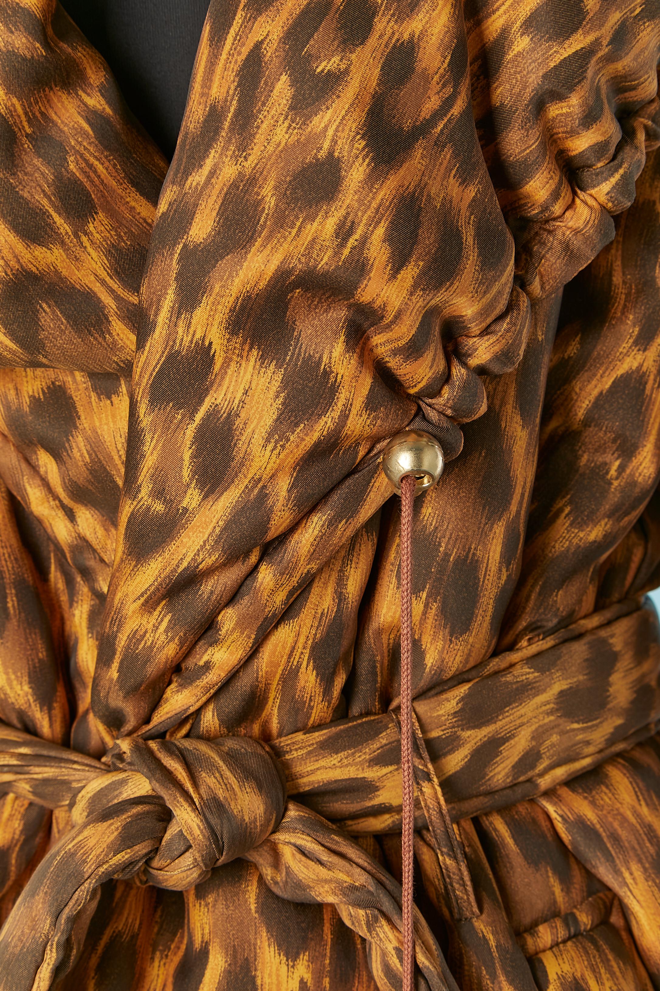 Gepolsterte Jacke mit Kapuze und Leopardenmuster. Zusammensetzung des Außenmaterials und Futter: 85% Polyester, 15% Nylon. Zusammensetzung des Pads: 100% Polyester. 
Raglanärmel. Kordelzug um die Kapuze  und auch die Schließung. Tasche auf beiden