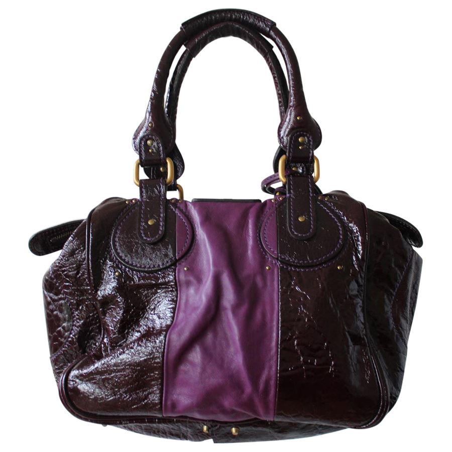 Leather and patent Purple color Two handles Double zip closure Internal zip pocket Bronze metal inserts Key locker with key Cm 45 x 26 x 12 (17.7 x 10.2 x 4.72 inches)
