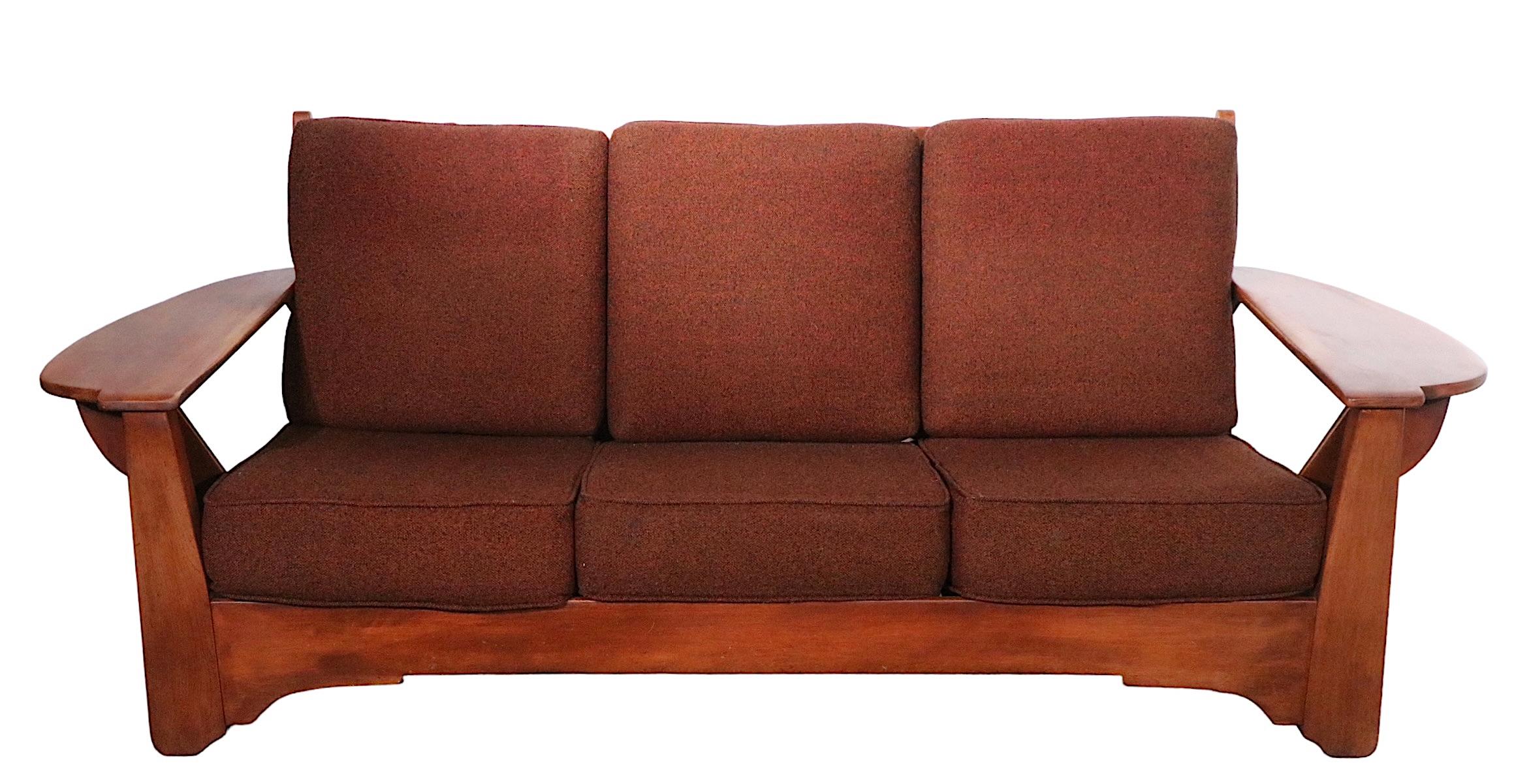 Exceptional full size Cushman Colonial Creations sofa, designed by Herman de Vries, circa 1940 -1950's. The sofa features an exaggerated wide paddle form arm, with a chic and sophisticated low slung profile. The solid maple frame supports the brown