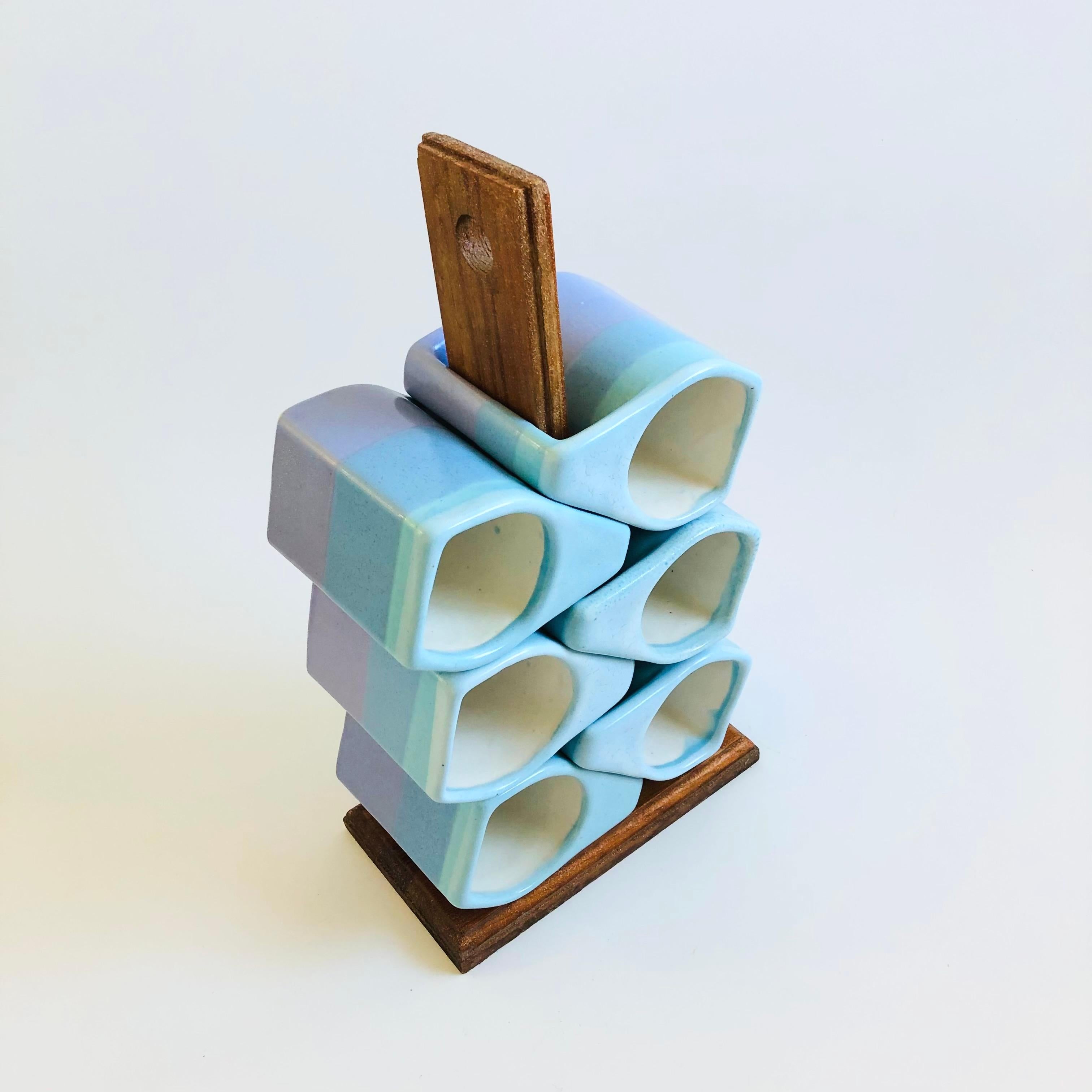 A set of 6 vintage handmade pottery mugs by Mexican sculptor and ceramicist, Rodolpho Padilla. Each features a unique blocky shape. Wonderful blue and purple glazes. Signed on the bases. Stacking neatly on the original wood stand.
Overall measures