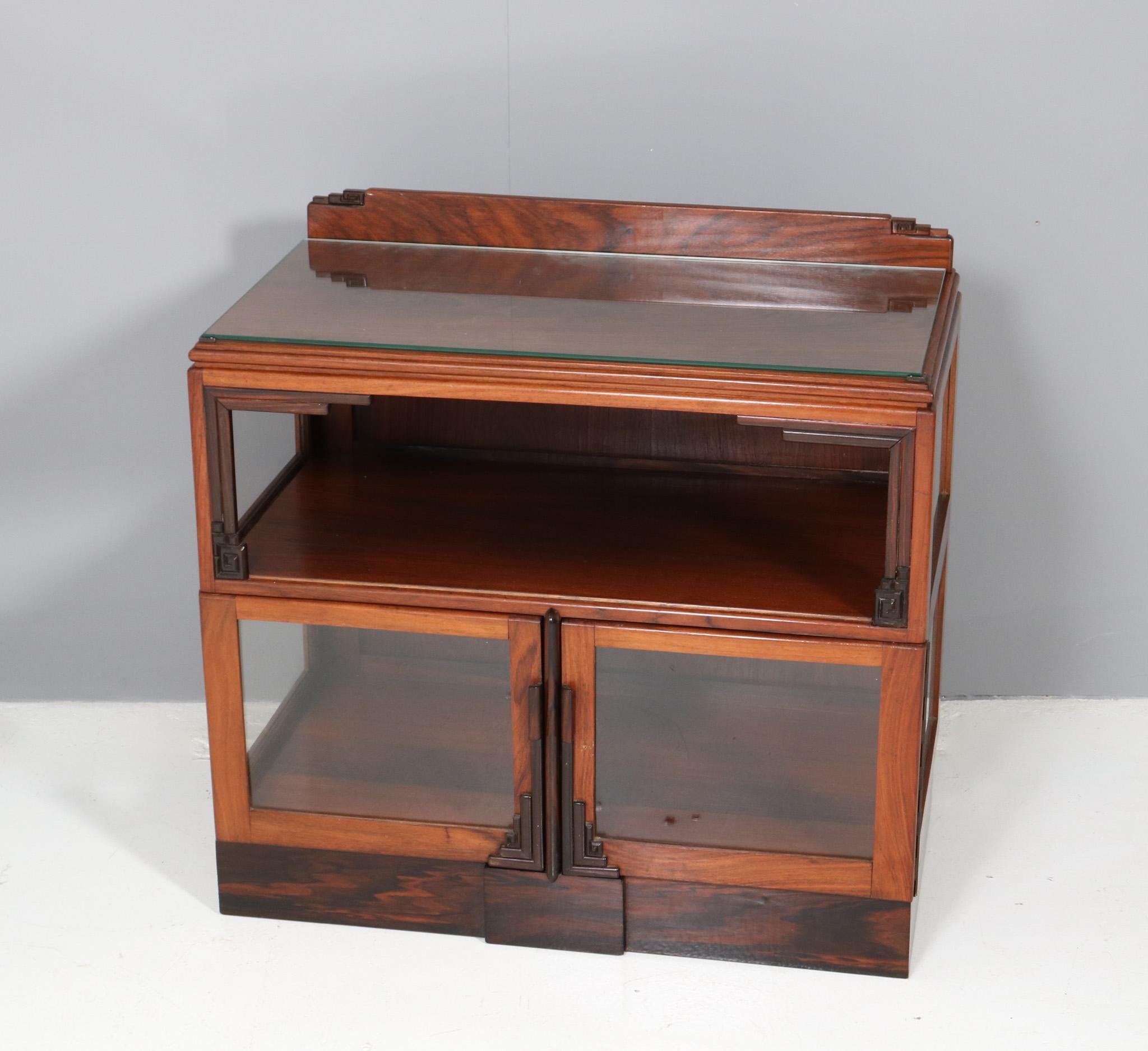Magnificent and rare Art Deco Amsterdamse School tea cabinet.
Striking Dutch design from the 1920s.
Solid padouk with decorative macassar ebony elements.
The original veneered padouk top has a glass top to protect the veneer.
This wonderful Art Deco