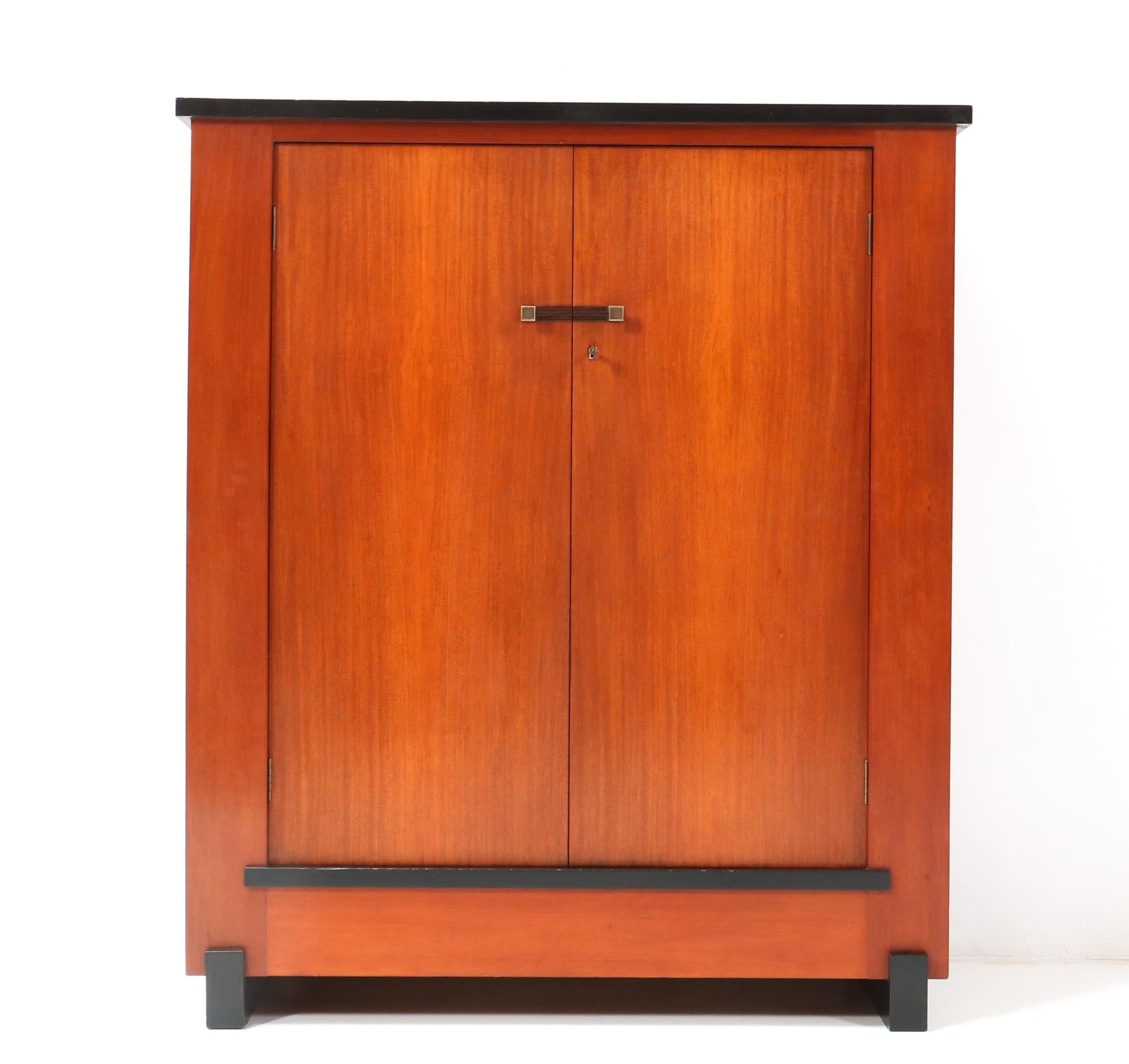 Magnificent and ultra rare Art Deco Modernist cabinet or cupboard.
Design by Hendrik Wouda for H. Pander & Zonen Den Haag.
Striking Dutch design from the 1920s.
Solid padouk with two original bronze knobs.
Two original wooden shelves, adjustable in