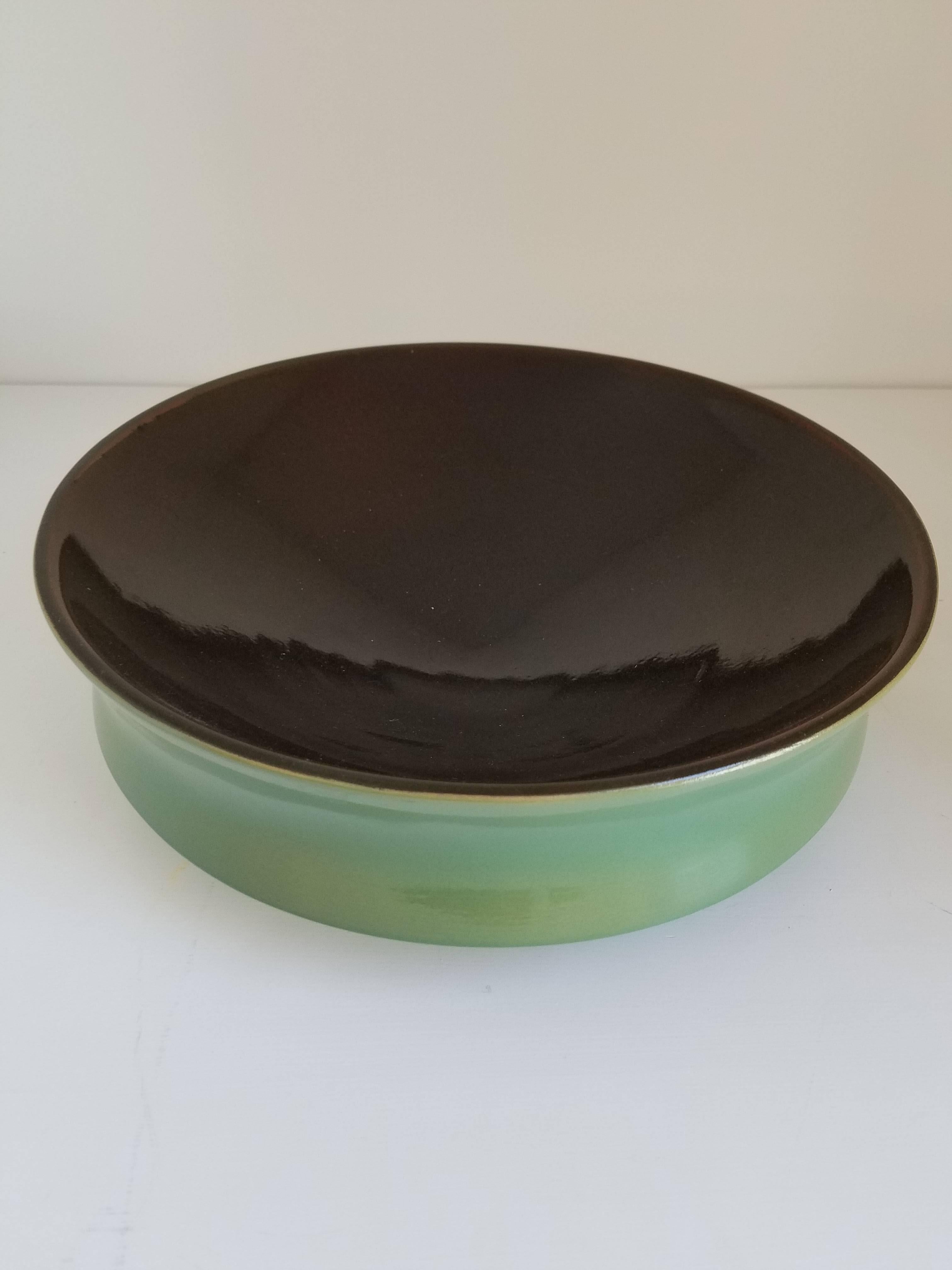 Hand thrown double glazed ceramic bowl with indented curved sides and contrast color glaze.