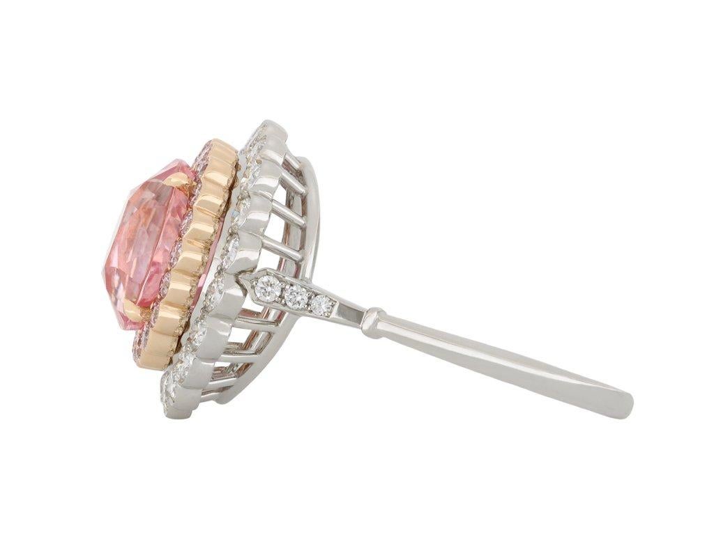 Padparadscha Ceylon sapphire and diamond ring. Set to centre with a cushion shape mixed cut natural unenhanced Padparadscha Ceylon sapphire in an open back claw setting with a weight of 4.16 carats, encircled by twenty round brilliant cut natural
