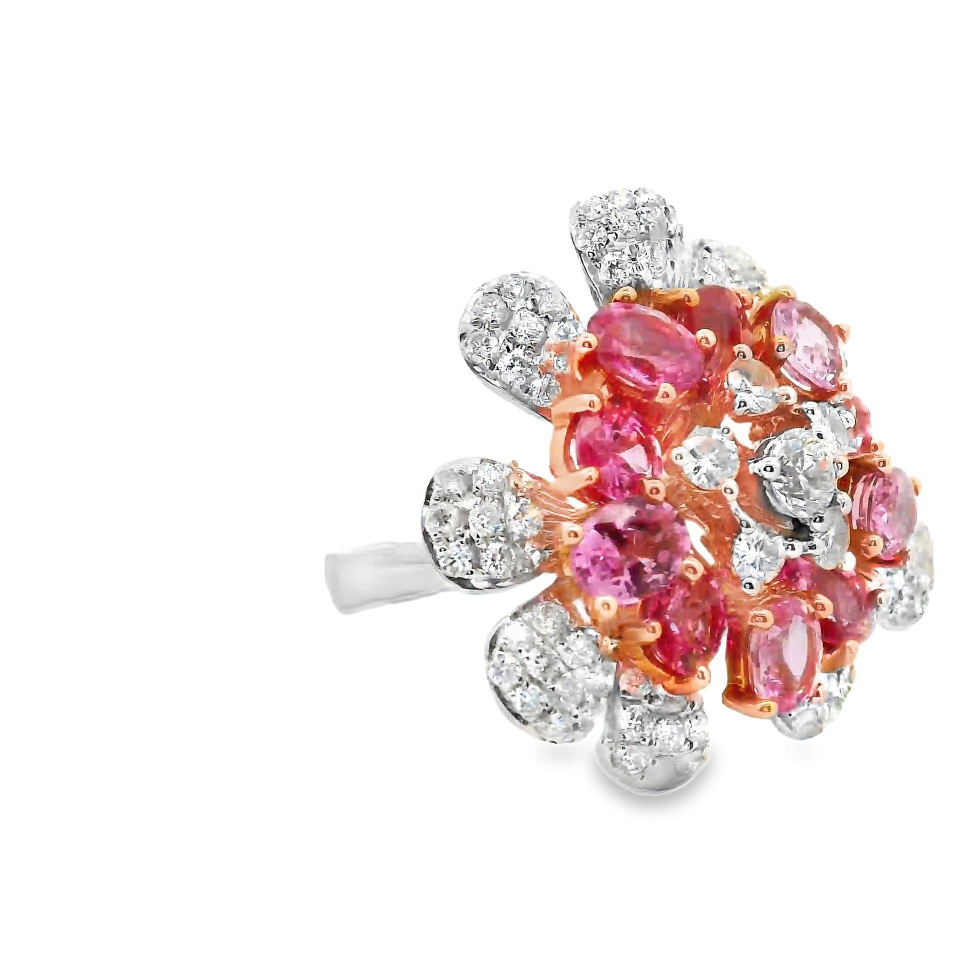 A fun and stylish flower ring featuring vivid pink sapphire and bright white diamonds. There are a total of 10 oval-shape pink sapphires, with a few being true Padparadscha, which weigh a total of 4.36 carats. They surround a cluster of larger round