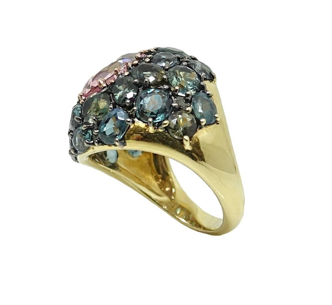 This Decorative 18K Yellow Gold Ring Has A Memorizing Oval Padparadscha Sapphire Set In The Center Weighing A Total Carat Weight Of 3.58 Carats. A Total Of 25 Lovely Alexandrite Stones Set Around The Padparadscha And Weigh A Total Carat Weight Of