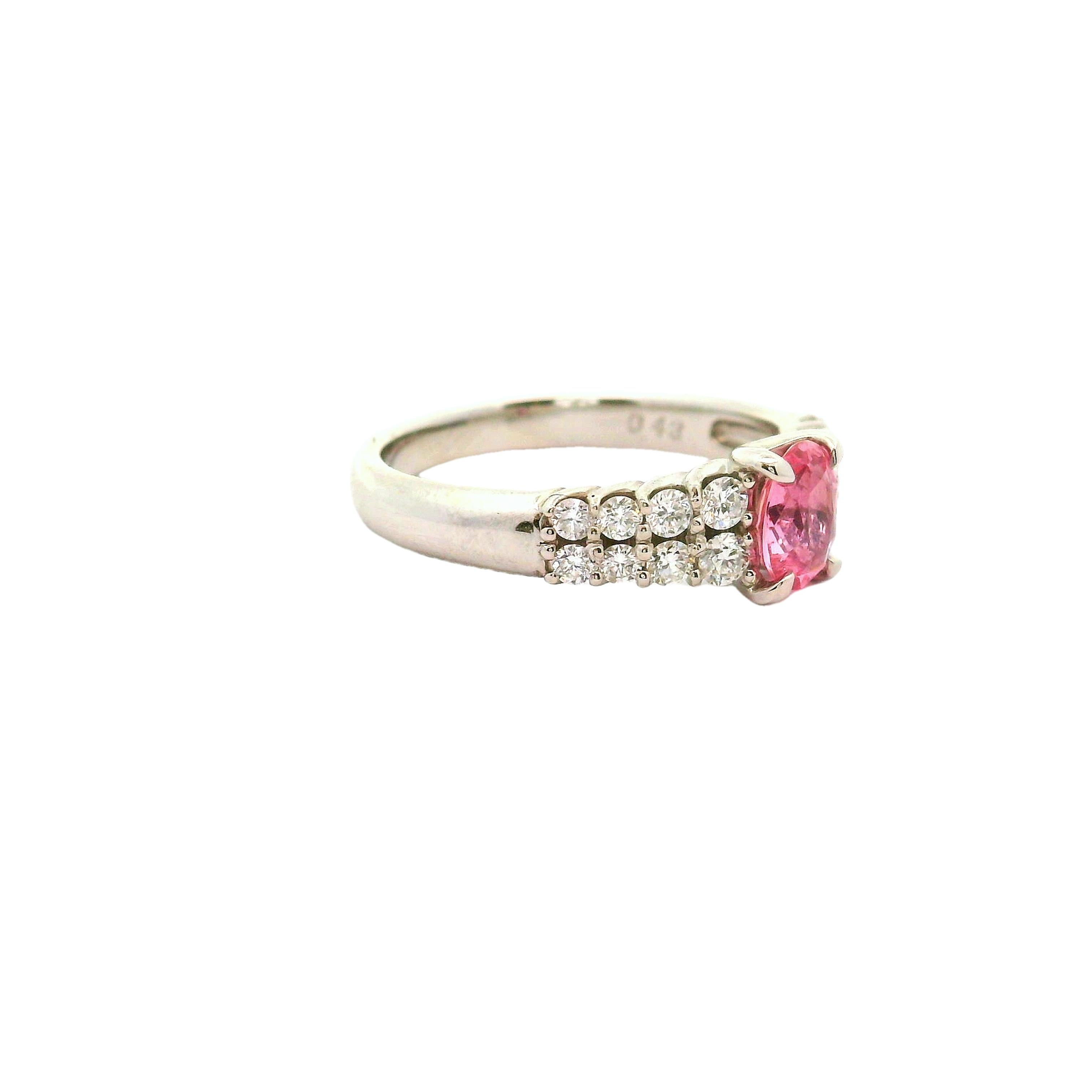 A contemporary fashion ring featuring a 0.65 carat oval Padparadscha sapphire as its centerpiece. The sapphire displays a captivating pink hue, complemented by 0.43 carats of round white diamonds, adding a touch of sparkle. Crafted in platinum, this