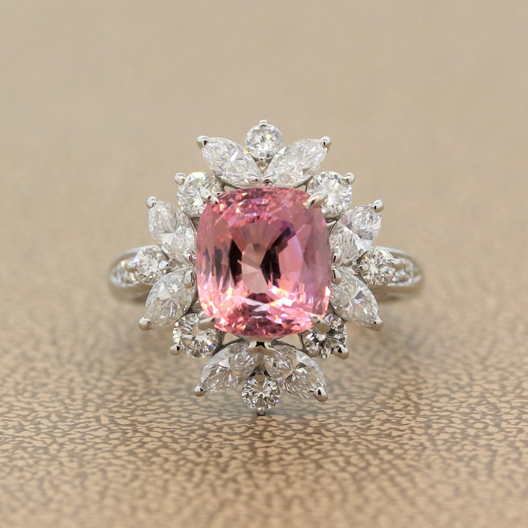 A stunning ring featuring a rare GIA certified 4.74 carat natural Padparascha sapphire. The pinkish orangy gem is from the original and most important source of Padparadscha sapphires, Sri Lanka. The gemstones is enclosed by a haloing cluster of