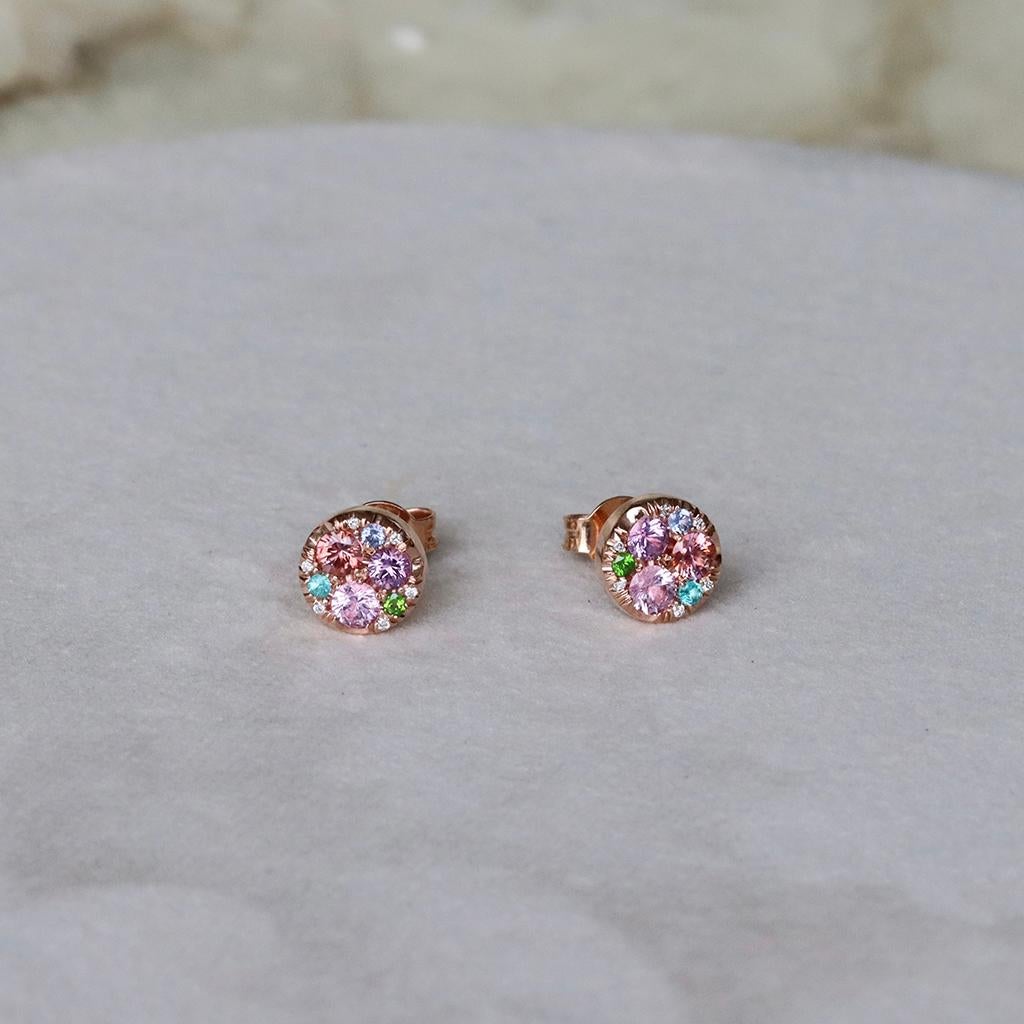 Handmade in Belgium by jewellery artist Joke Quick, these earrings are truly one of a kind. 

These rose gold stud earrings display mesmerizing padparadscha Sapphires, purple and pink sapphires, Paraïba tourmalines, demantoid garnets, no heat blue
