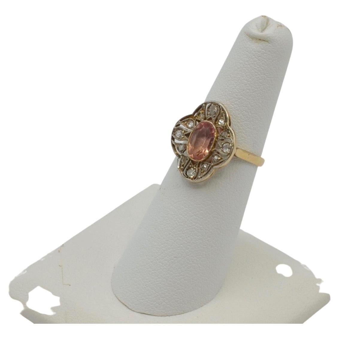 This stunning French 'Turn of the Century' Ring is a beautiful light peach pink Padparadschah Sapphire surrounded by Platinum filigree set diamonds. The carat wight of the diamonds is approximately 0.30 carats. The ring is a size 6 and can be sized