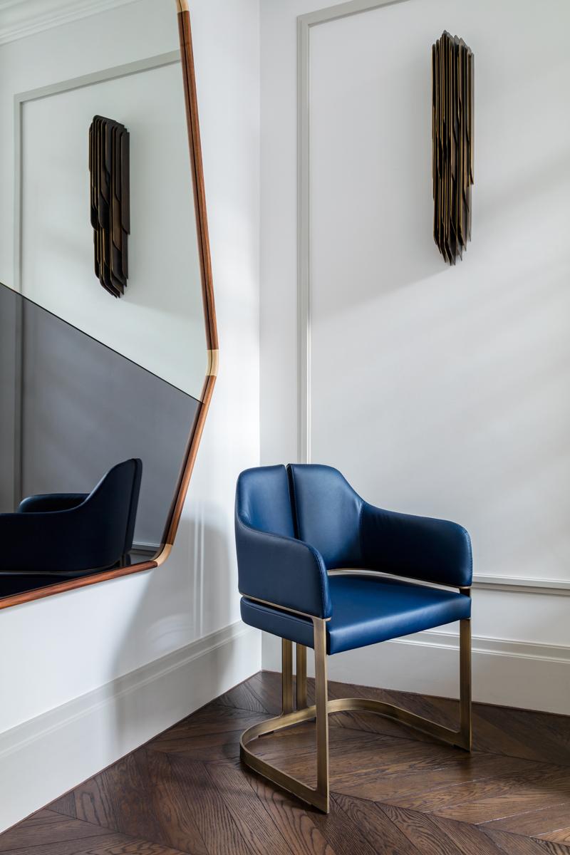 Padus dining and host chair are a graceful, contemporary nod to Art Moderne. A refined curvilinear metal base majestically elevates and defines the upholstered seat and back which similarly echoes the vertical reveal of the base. Available both with