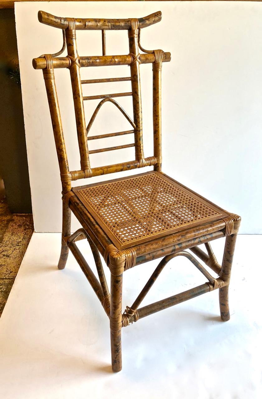 This is a highly decorative set of 4 pagoda-backed side chairs attributed to Ficks Reed. The chairs are crafted in flamed bamboo and date to the last quarter of the 20th century. The chairs feature high pagoda form backs and caned seats.