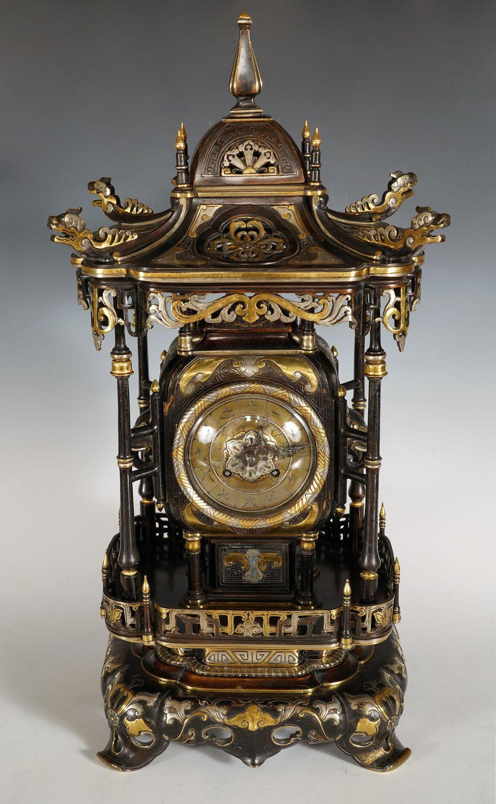 Beautiful Japonisme clock in openwork patinated bronze with gold and silver highlights in the shape of a pagoda, at the corners presenting stylized dragons above uprights imitating bamboo.
The dial, with calligraphed numbers in Kanji and hands