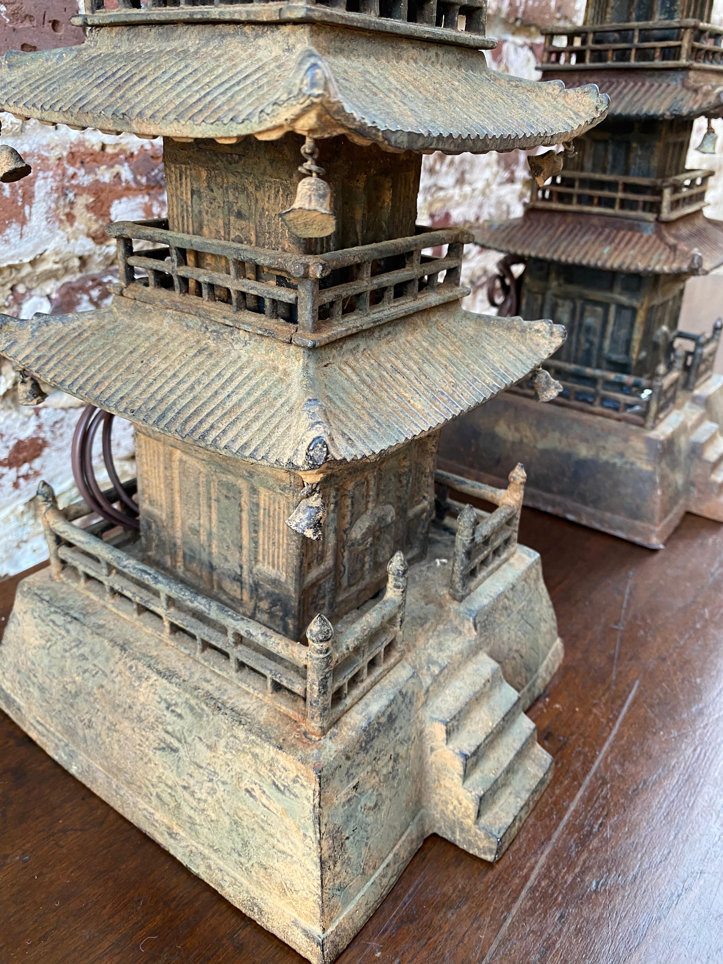 Pagoda form cast iron decorative pieces convert to lamps.