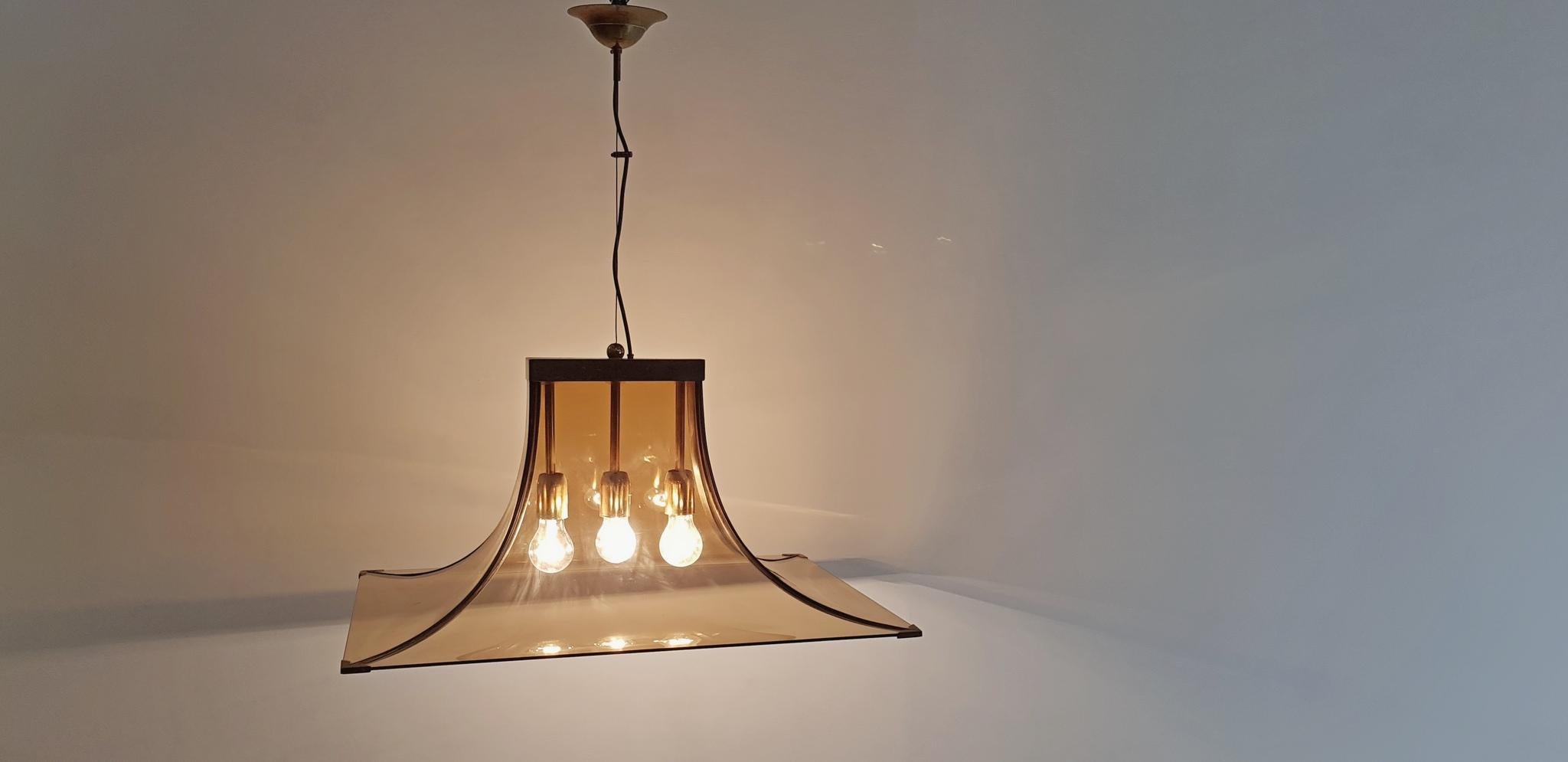 Pendant lamp by Esperia, Italy. Has smoke colored glass that gives a warm glow to the room. The glass sits on a brass structure and it uses E40 lightbulbs. Works in the US as well as Europe. The height can be varied with the steel wire which