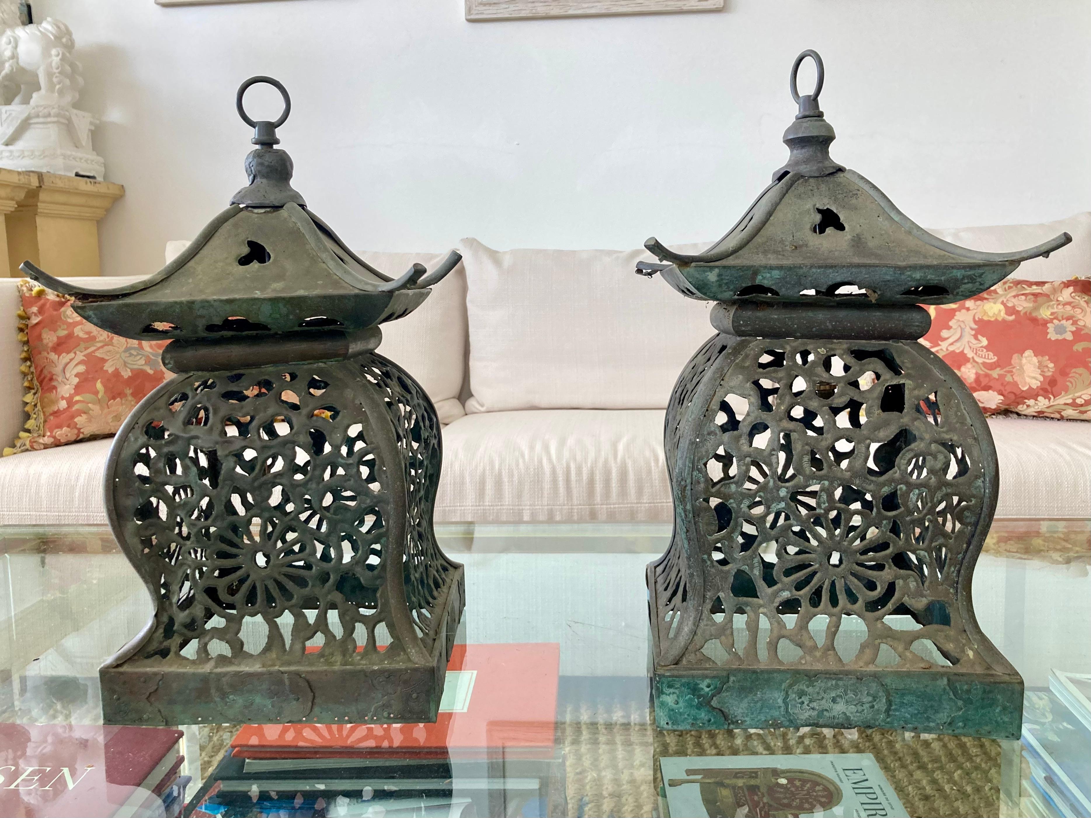 Pair of beautiful metal pagoda lanterns. These are thin bronze with a beautiful patina finish. They are not electrified, but could easily be wired by your electrician or lamp workroom. Great addition to your patio and garden or interiors. Currently,