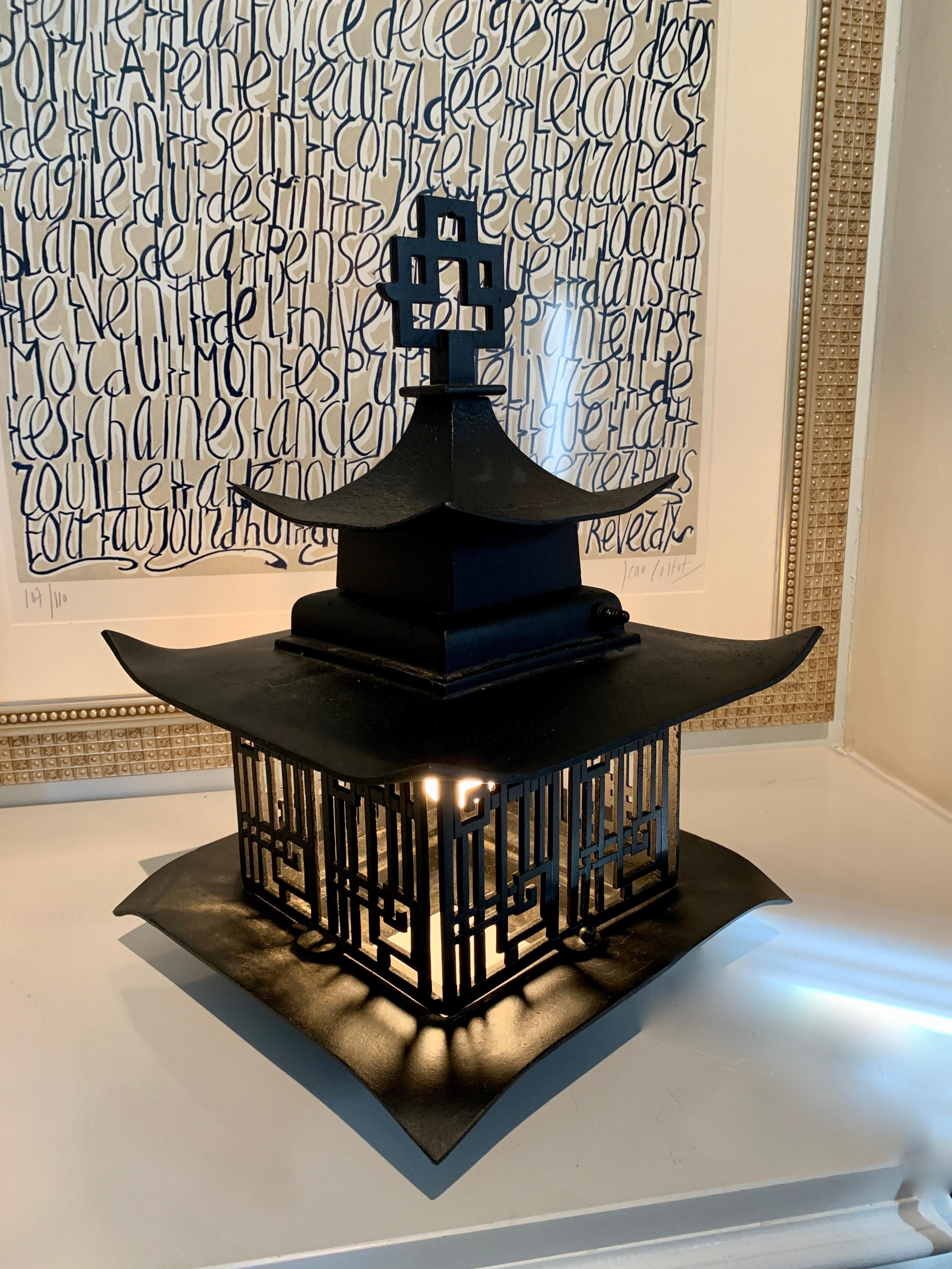 Midcentury Asian lantern, a pagoda style metal light. The lantern is wired for placement outside and sat on the ground, a shelf or table, however could be re-wired to allow hanging. The on off switch is a push button and very discreet, and is not
