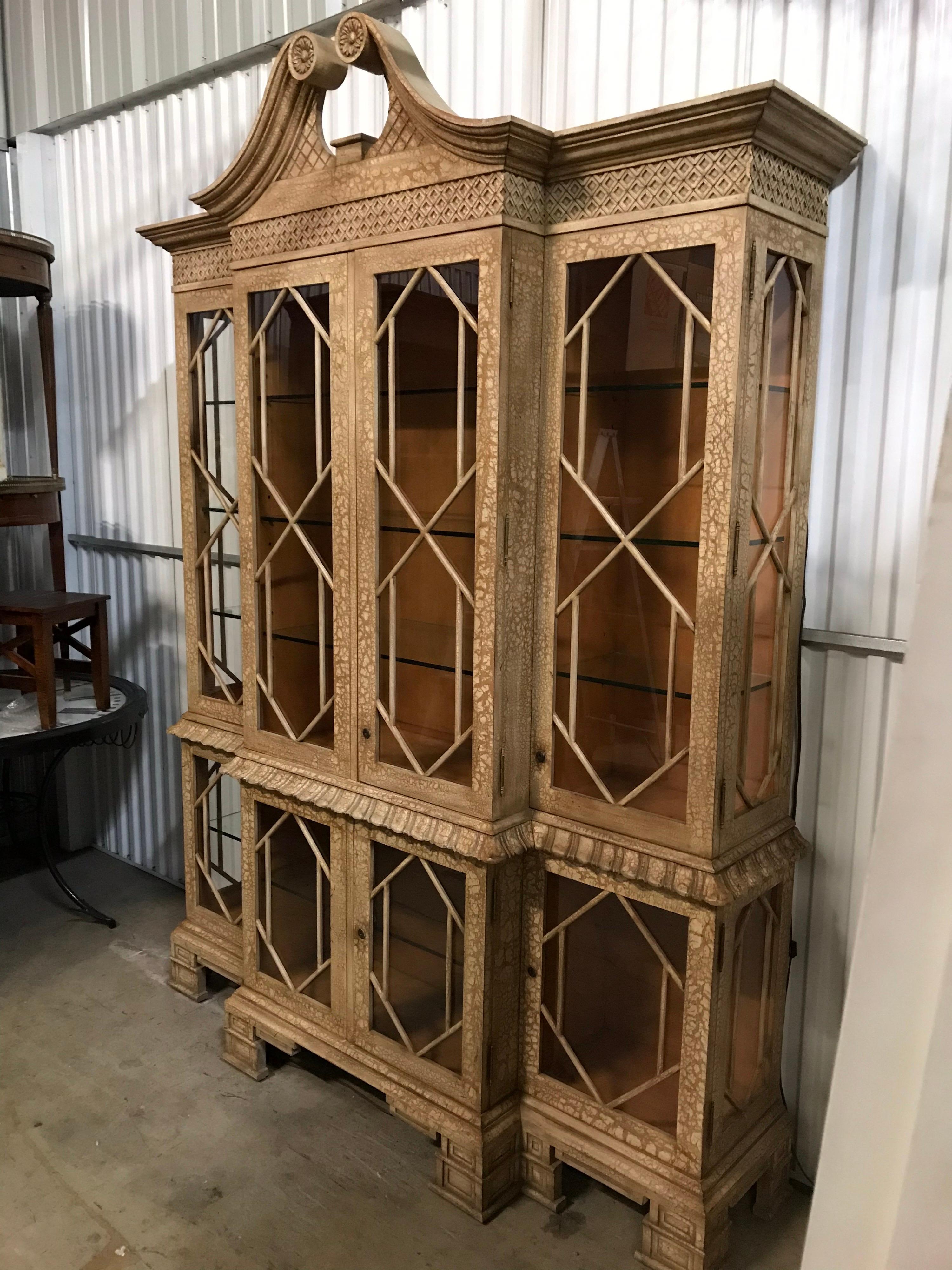Very unique Pagoda style display cabinet with glass doors on both bottom and top. Both sections are illuminated. Beautiful fretwork detail trim.