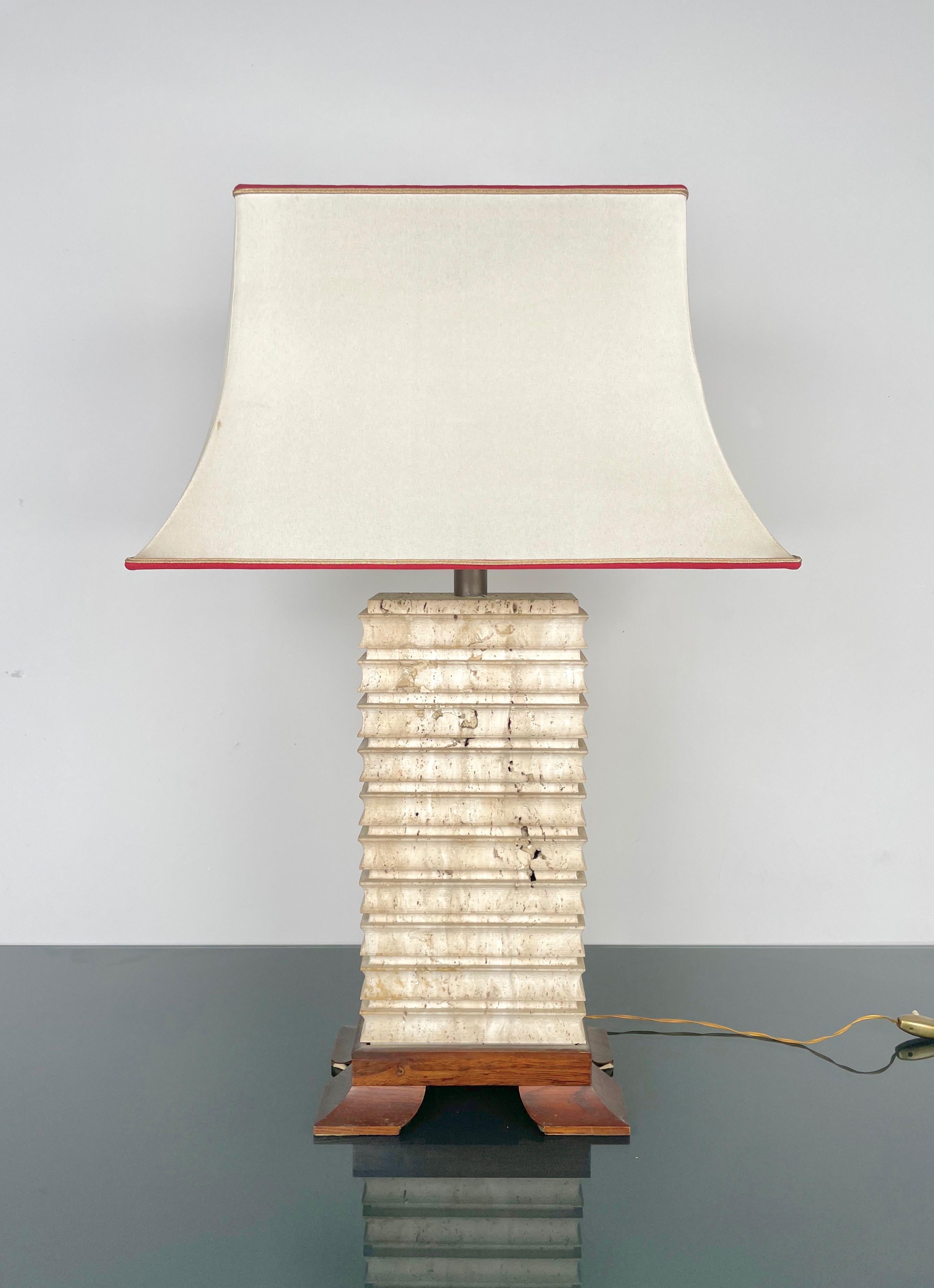 Elegant big table lamp in travertine marble with heightened base in wood and brass featuring its original lampshade in silk. 

Made in Italy in the 1970s.