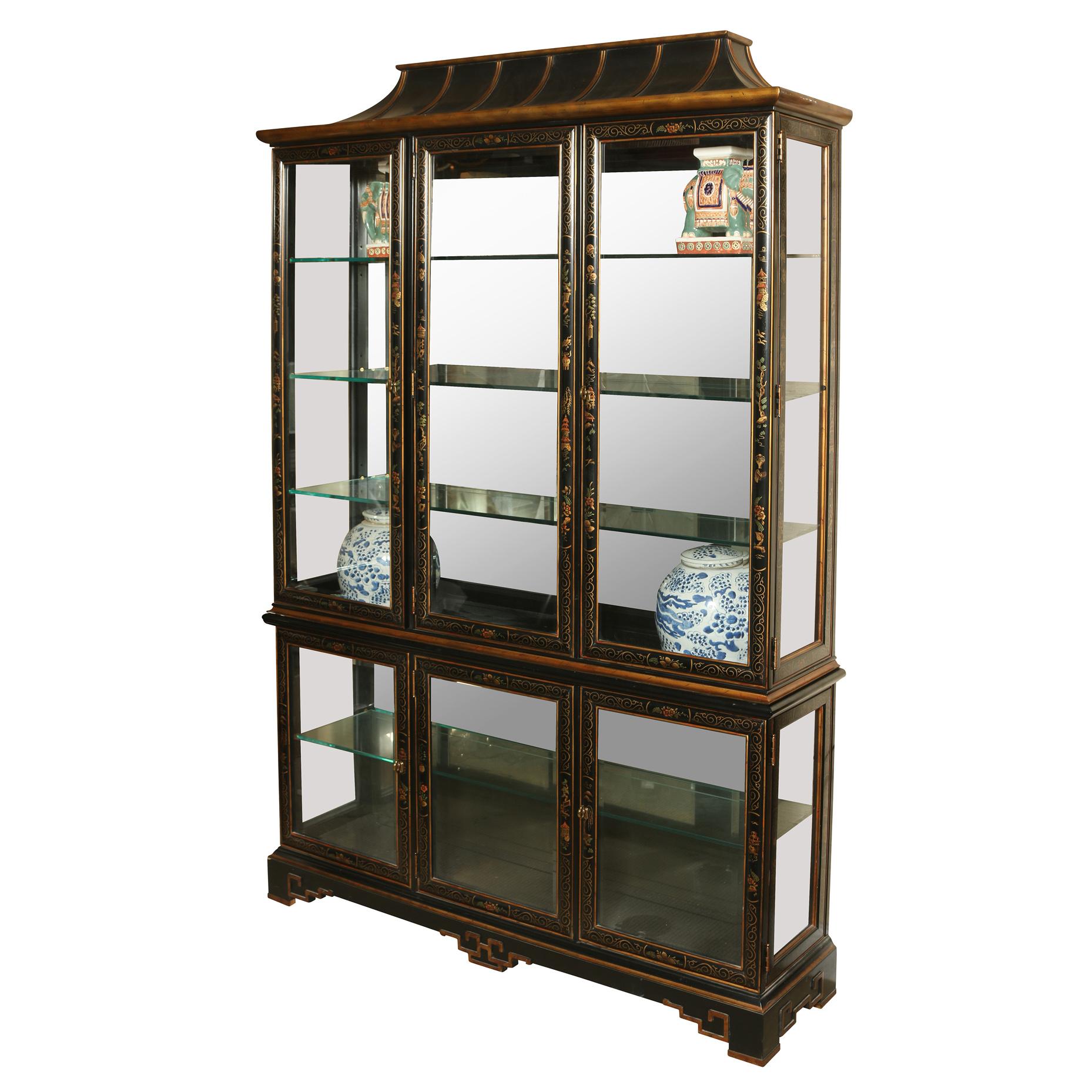 The pagoda top breakfront cabinet, an exquisite piece that seamlessly blends classic sophistication with an infusion of Chinoiserie charm. This captivating cabinet is finished in a sleek black hue, accentuated by meticulously painted gold details