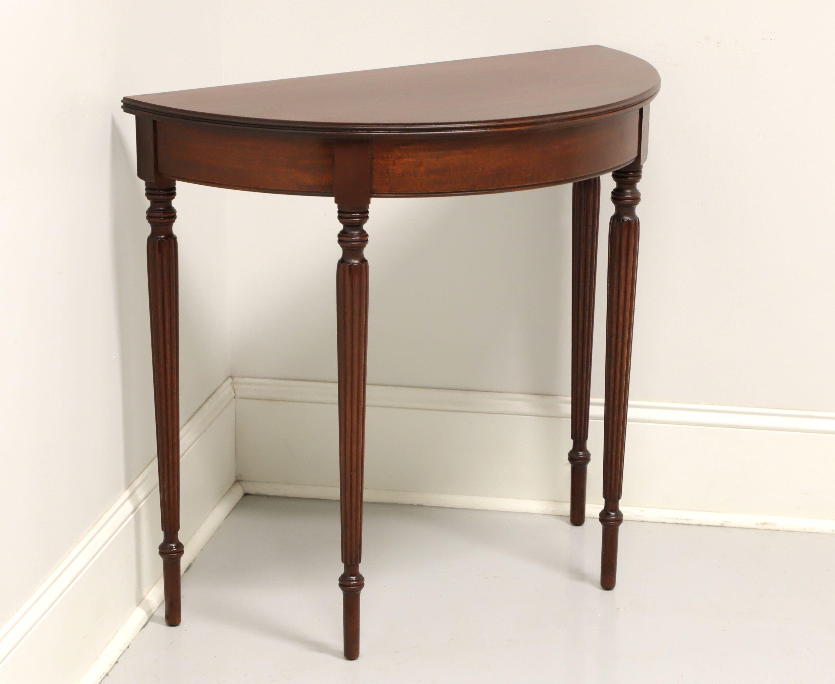 An antique Sheraton style demilune console table by Paine Furniture, of Boston, Massachusetts, USA. Solid mahogany with demilune (half moon) shape, ribbed edge, and fluted legs. Made in the early 20th Century.

Measures: 32W 15.75D