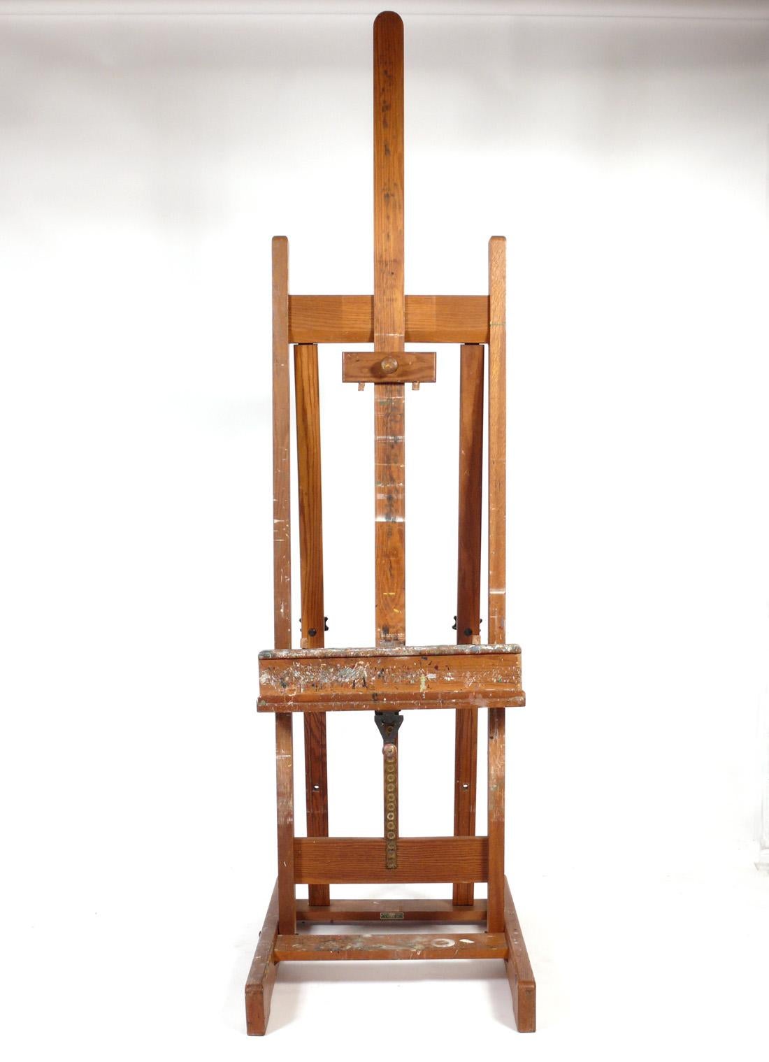 Paint Covered Artist's Easel by Weber, American, circa 1950s. This piece retains it's wonderful original paint covered patina. It can be used to hold a large painting or as a flat screen TV stand.