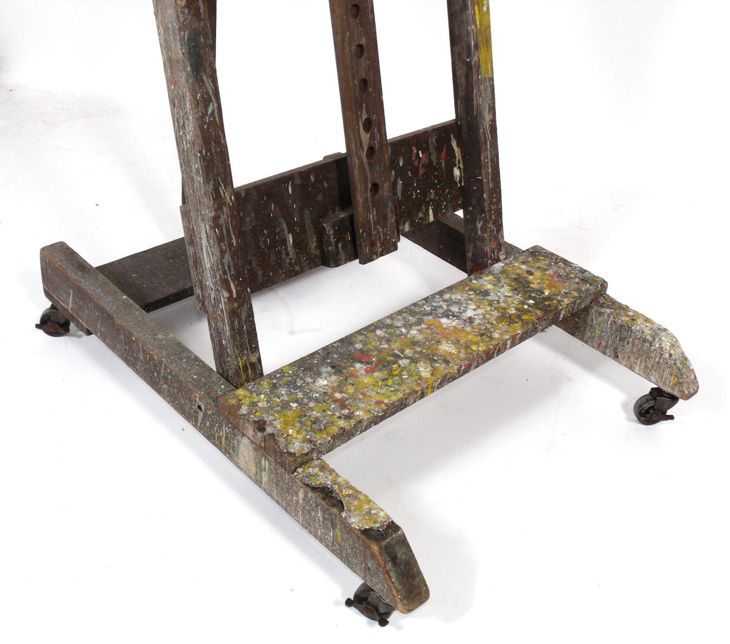 Paint Covered Artist's Easel, American, circa 1950s. This piece retains it's wonderful original paint covered patina. It can be used to hold a large painting or as a flat screen TV stand.