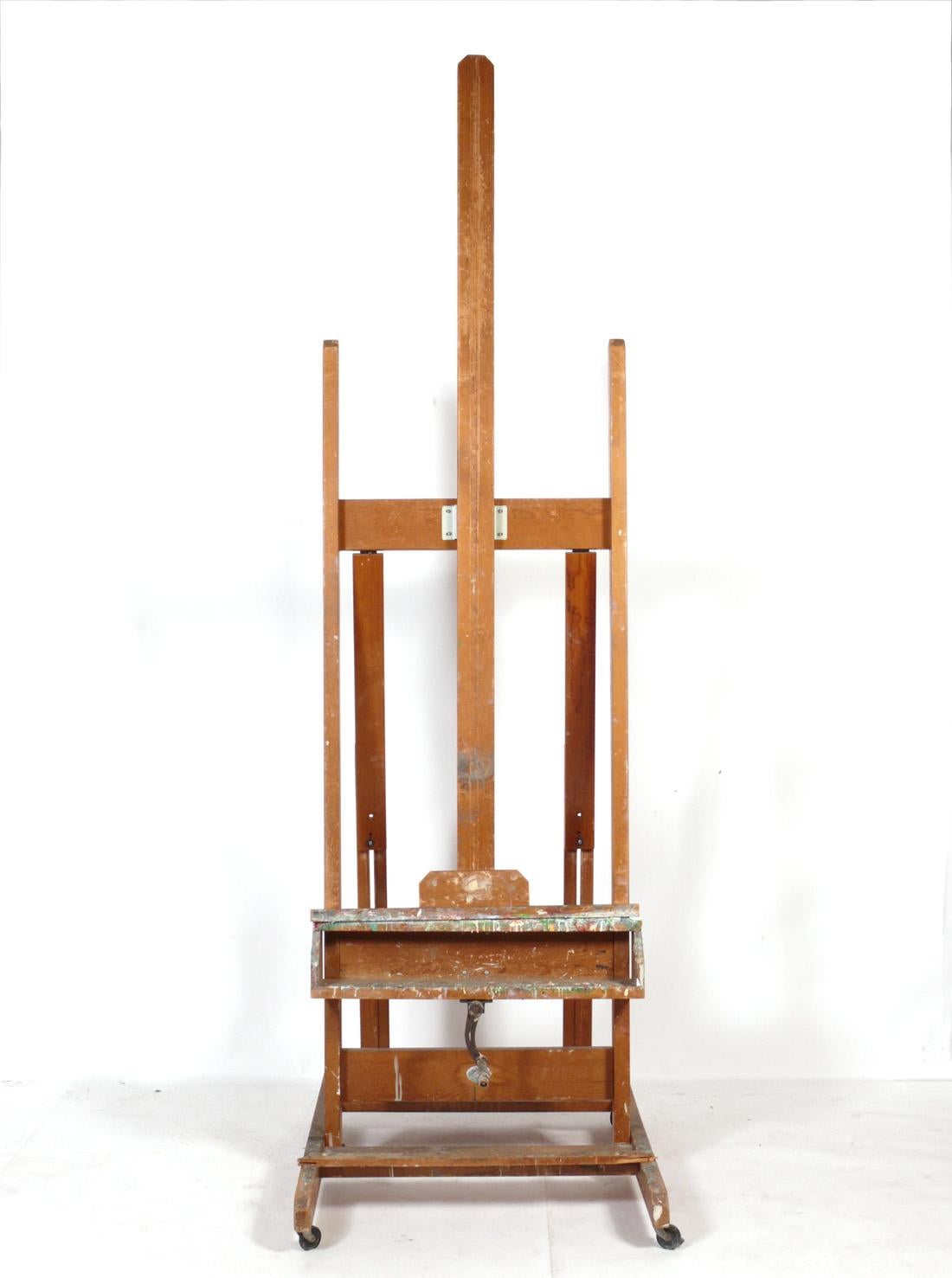 Paint covered Artist's wood easel, made by Anco Bilt of NY, American, circa 1960s. Retains beautiful original paint covered patina. It is a versatile size and can be used to paint with, or to display a painting or television. The shelf opening