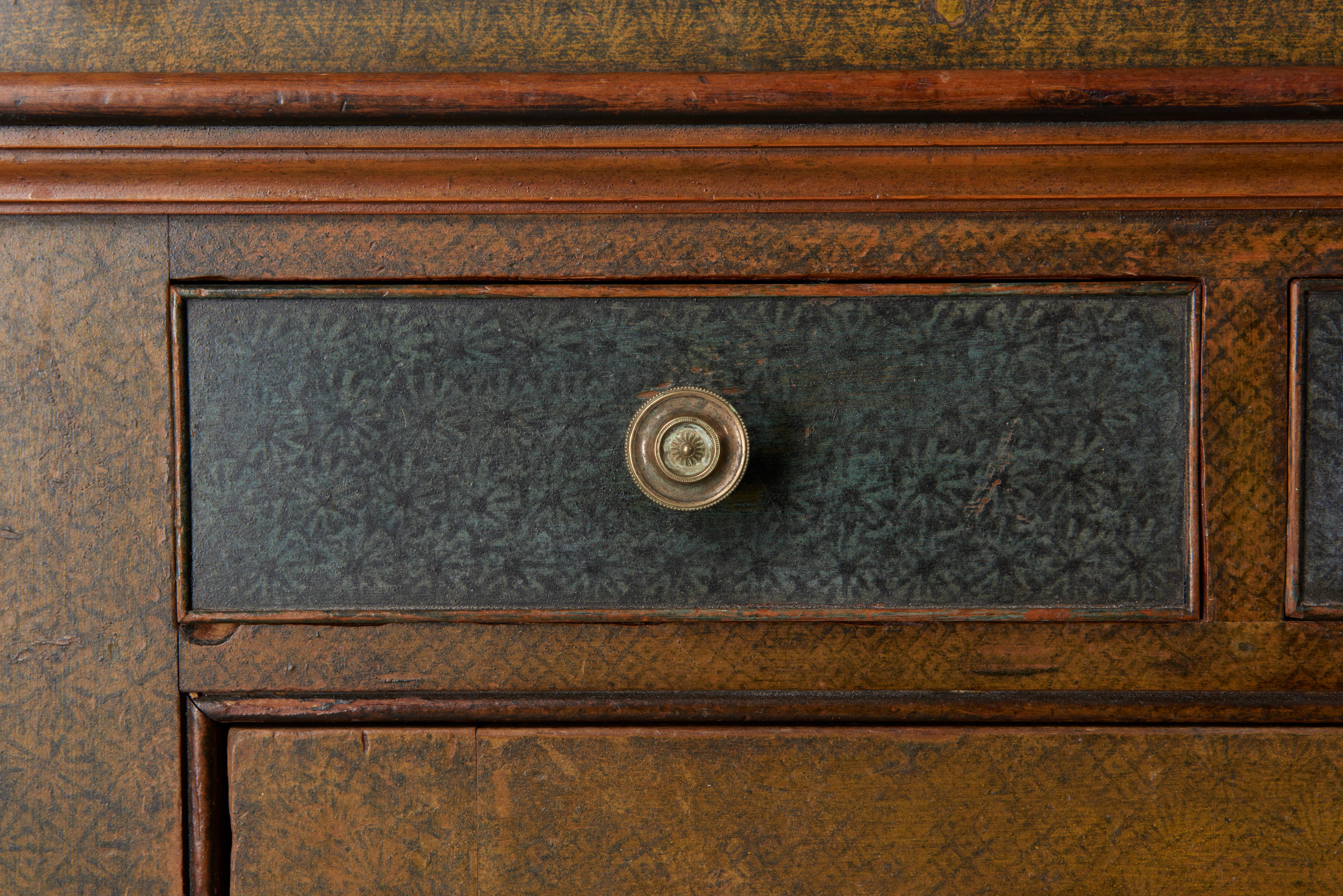 Original paint decoration with unique yellow, blue and white stamped surfaces with a salmon border. Maker's inscription with the date 1832 on the underside of the right drawer. A handsome corner cupboard from Pennsylvania with outstanding decoration