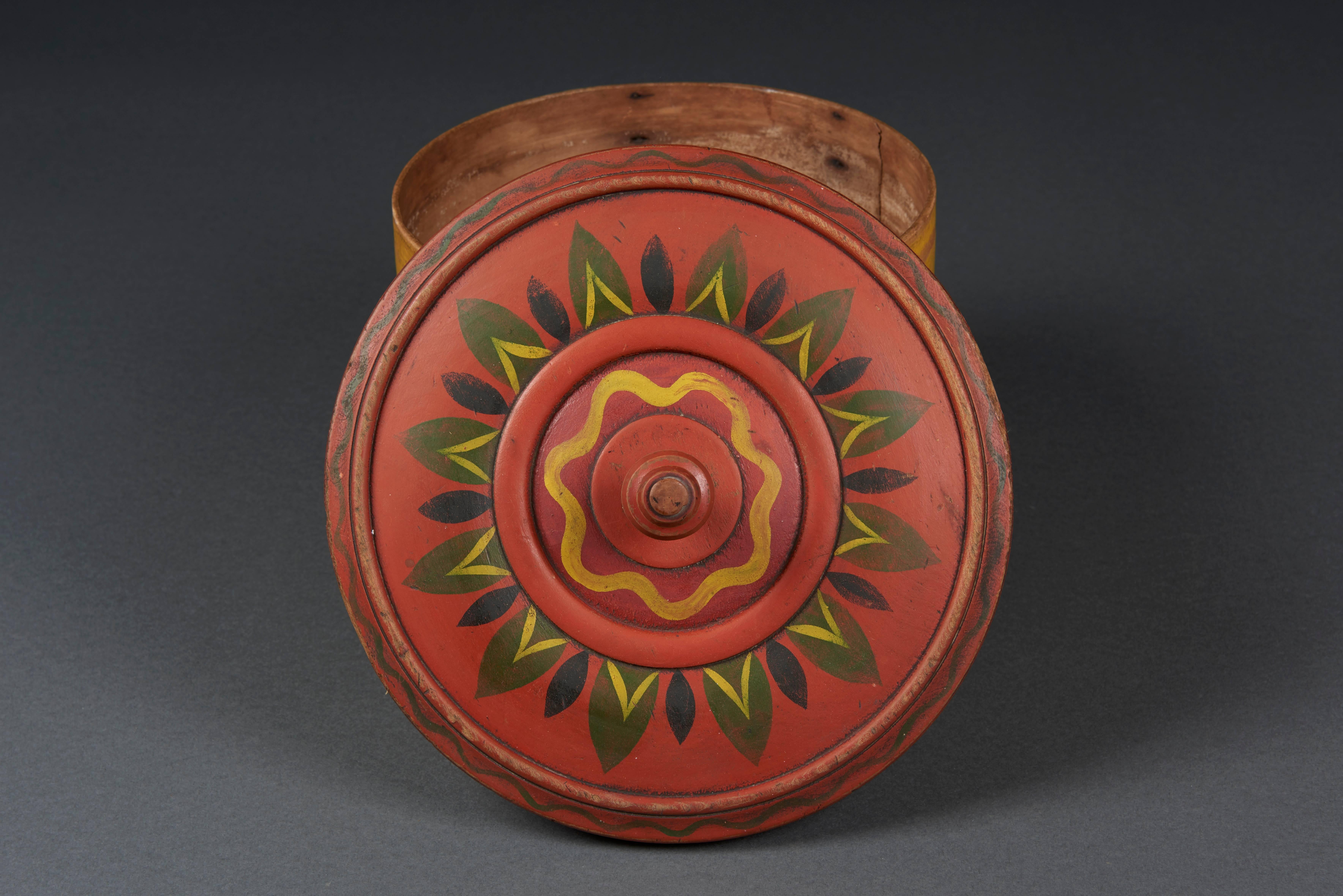 This paint decorated donut box is an excellent example of Pennsylvania-German decorative art with outstanding paint and carved elements. All original paint decoration in bright colors on a very regional form. Made between 1820 and 1830. A statement