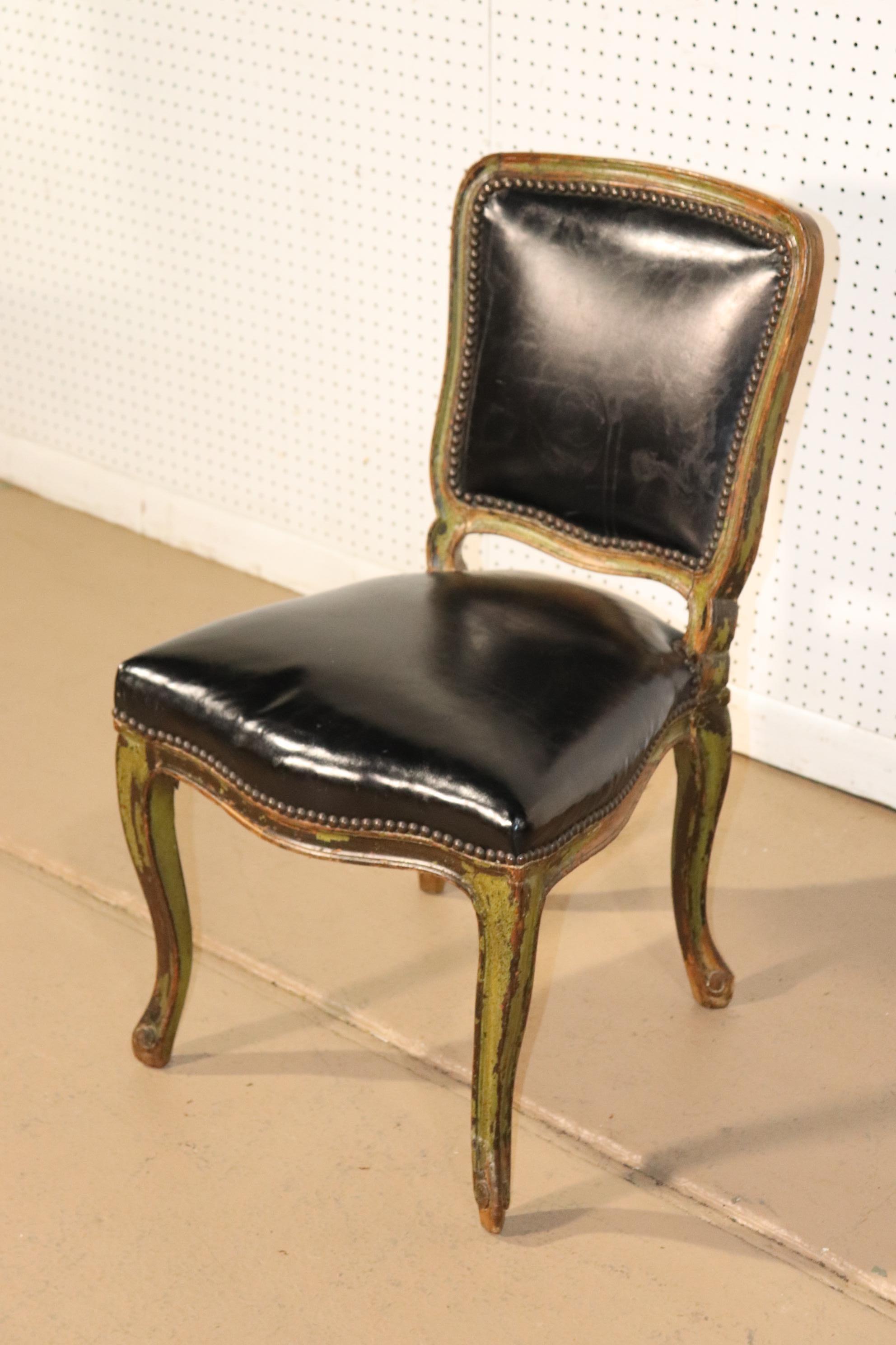 This is a beautiful leather chair from the early 1900s. The painted frame has traces of green paint over the walnut and adds tremendous character to the chair. The black leather is in good condition. The chair measures 33 tall x 19 wide x 21 deep