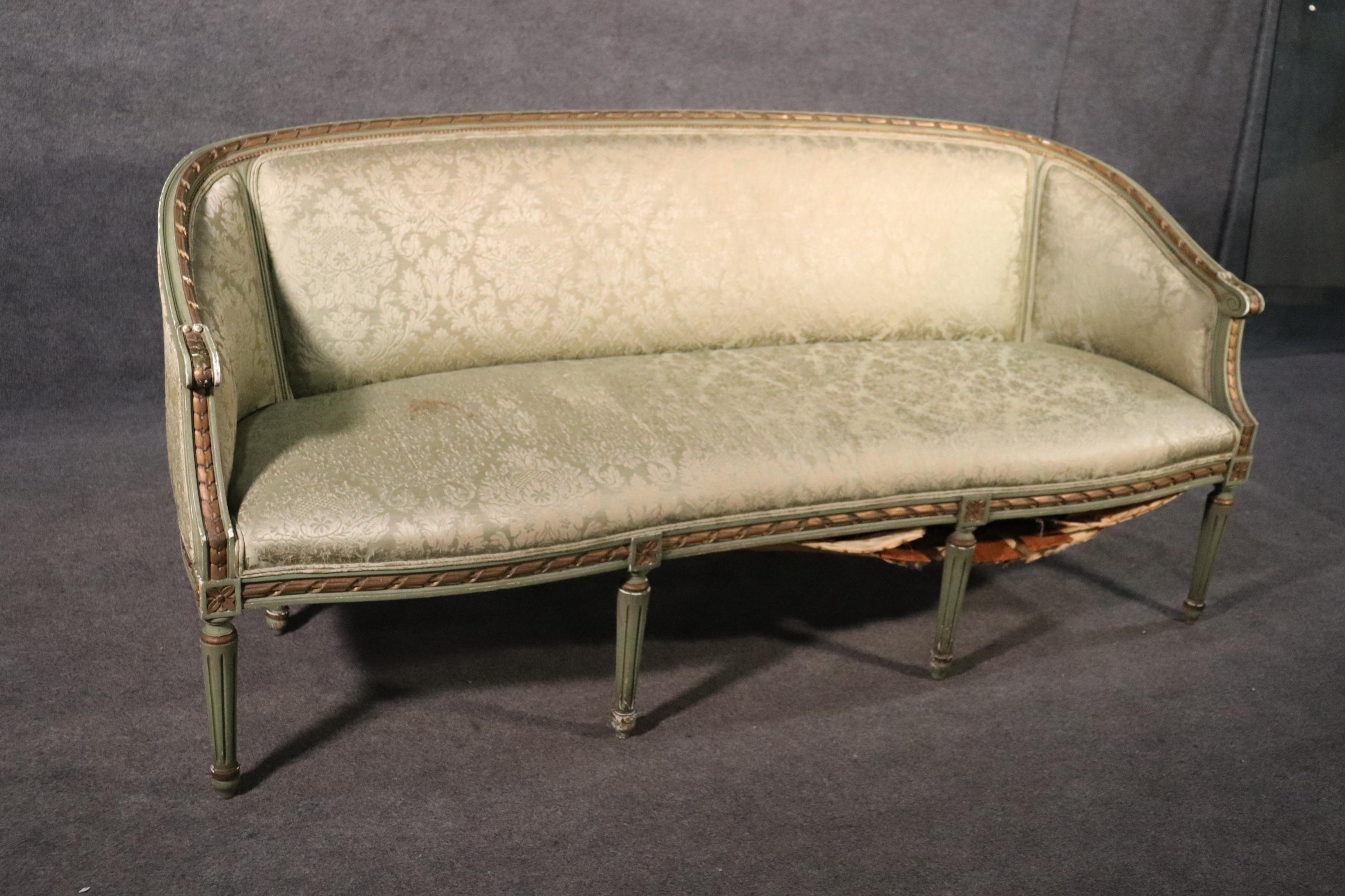 This is a gorgeous carved Louis XVI settee with a great painted and gilded carved frame. The settee features its original paint and damask upholstery which is vintage and does have some minor staining which may be able to be cleaned. The burlap base