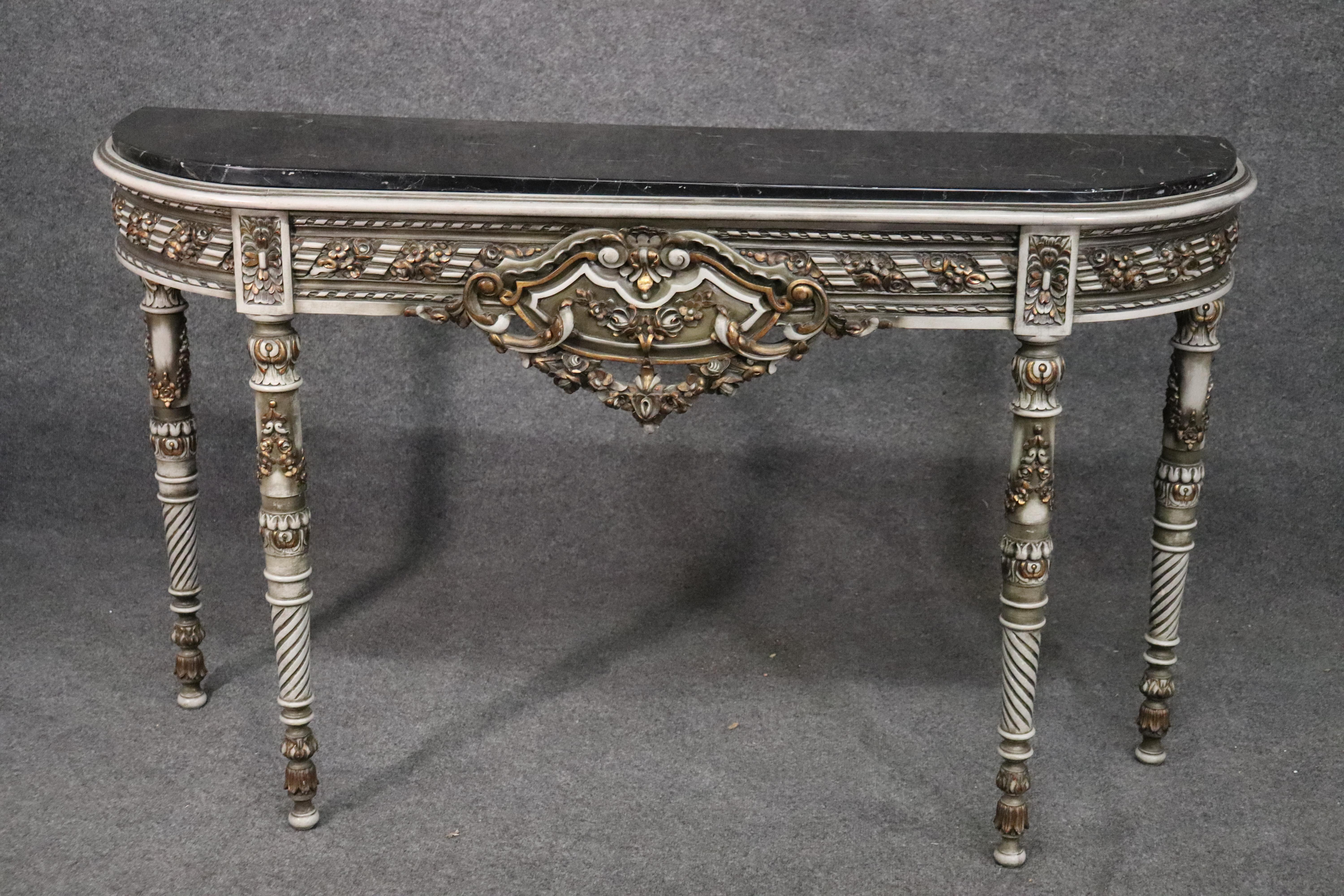 This is a spectacular French paint decorated marble top console table. The table features beautiful carving and a wonderful aged crème painted finish with gilded highlights. The table top is in very good condition as is the rest of the table. The