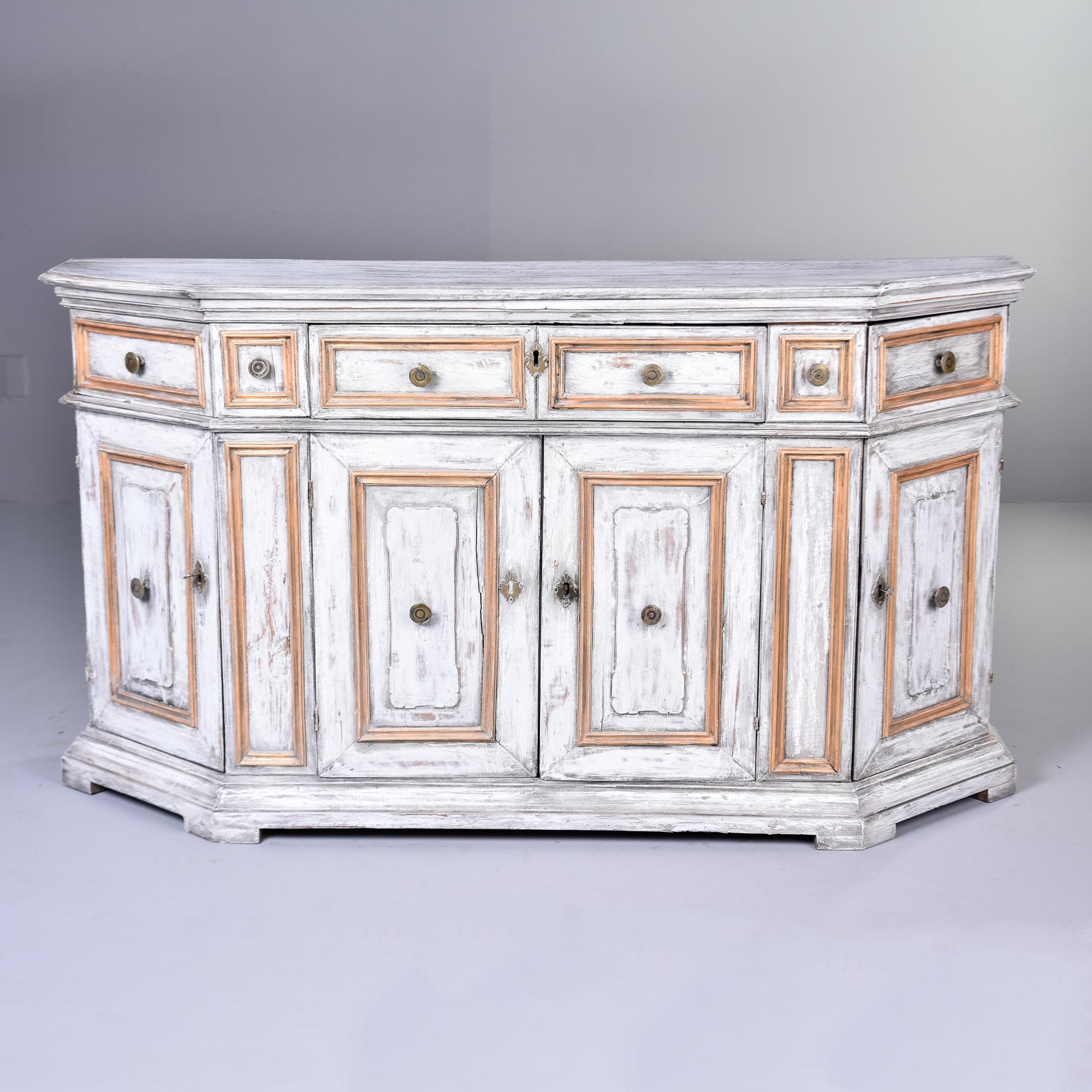 Found in France, this circa 1880s painted bow front cabinet has three functional drawers on the top level plus one false drawer front. Round brass pulls, antique white paint with gilt detailing on drawer and door panels. Bottom center cabinet has a