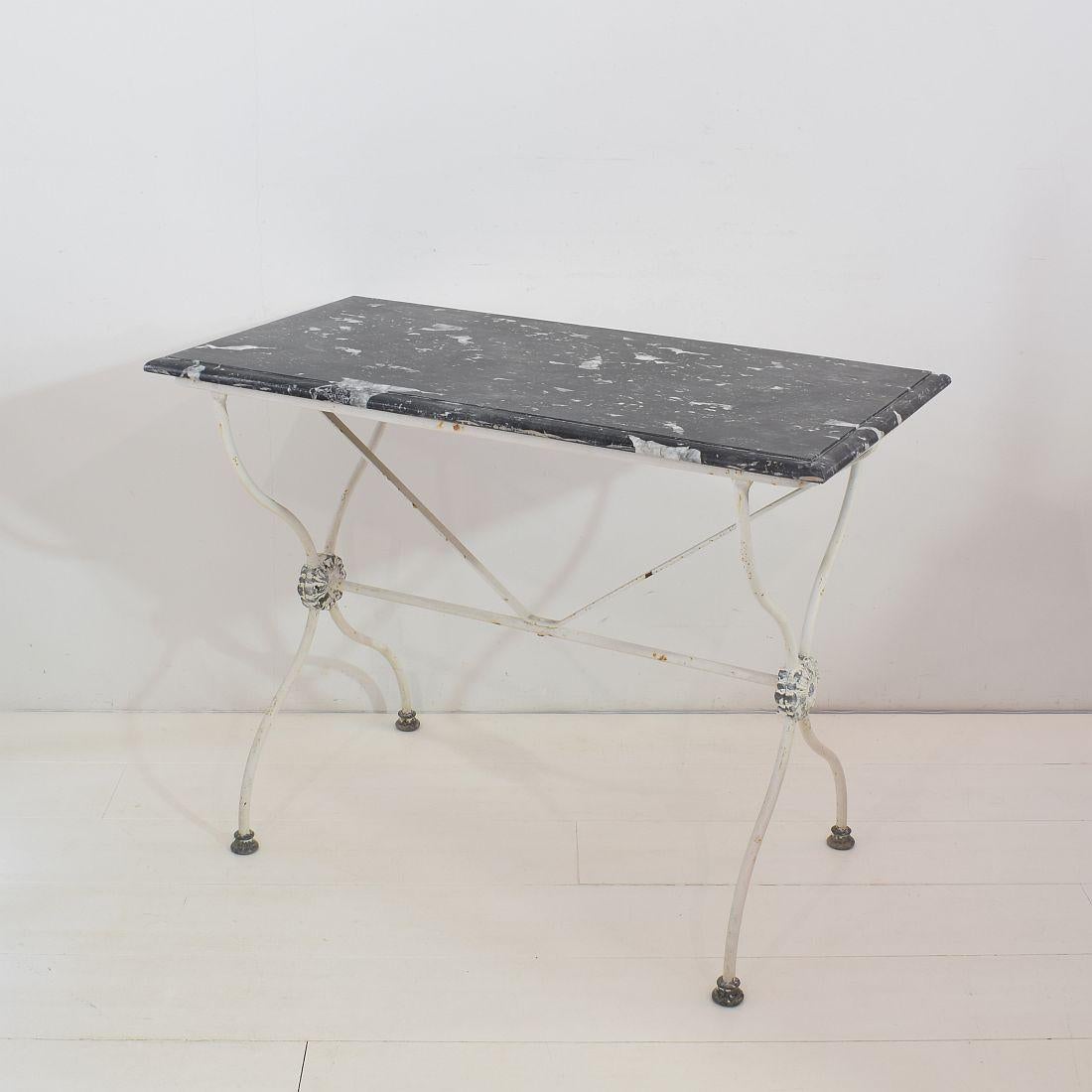 Beautiful iron marble-top garden table with lead details. Weathered black marble/Belgium blue stone and painted Iron base. Nice to use as a console. Really great piece.