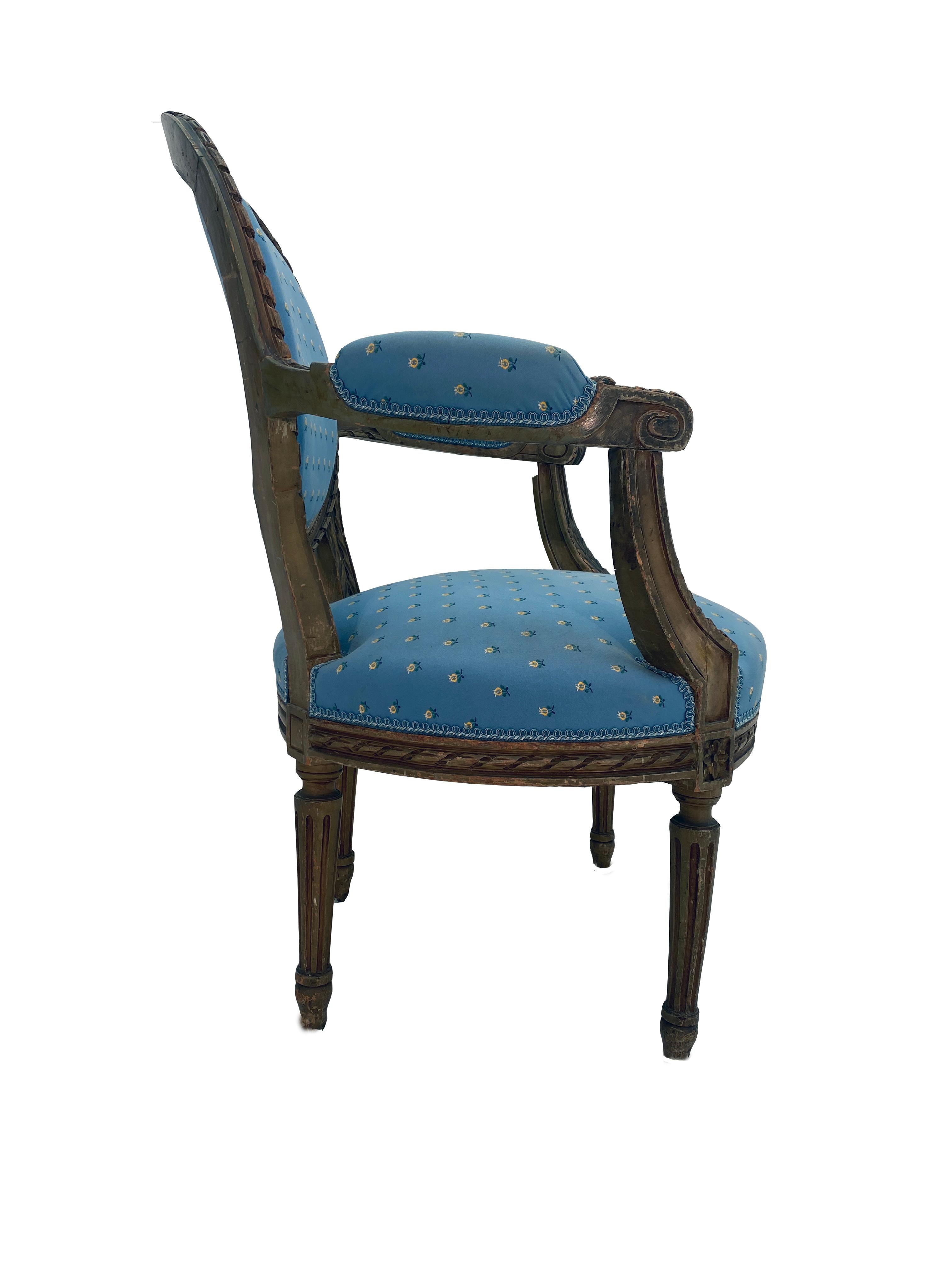 This is a Classic French Louis XVI arm chair in remarkable condition. The chair was made from solid walnut. It is very solid with no signs of previous damage or repairs. The upholstery has been updated and the fabric is in outstanding condition with